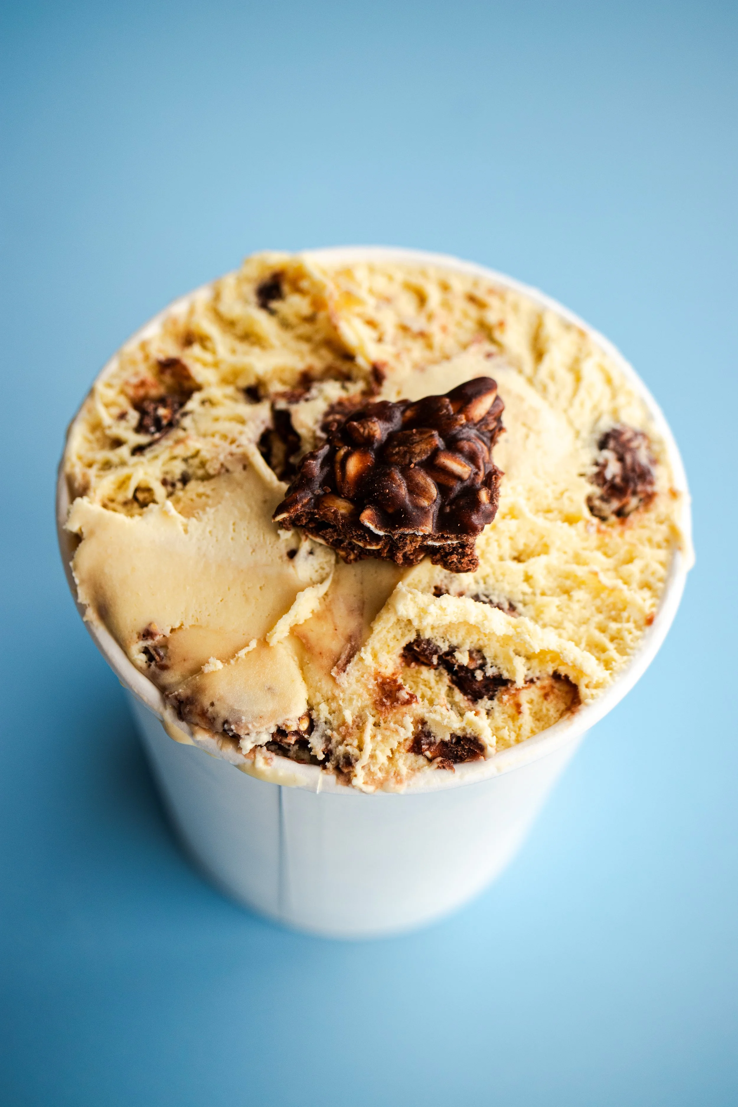 Overhead shot of banana ice cream with no-bake cookie chunks on a blue background.