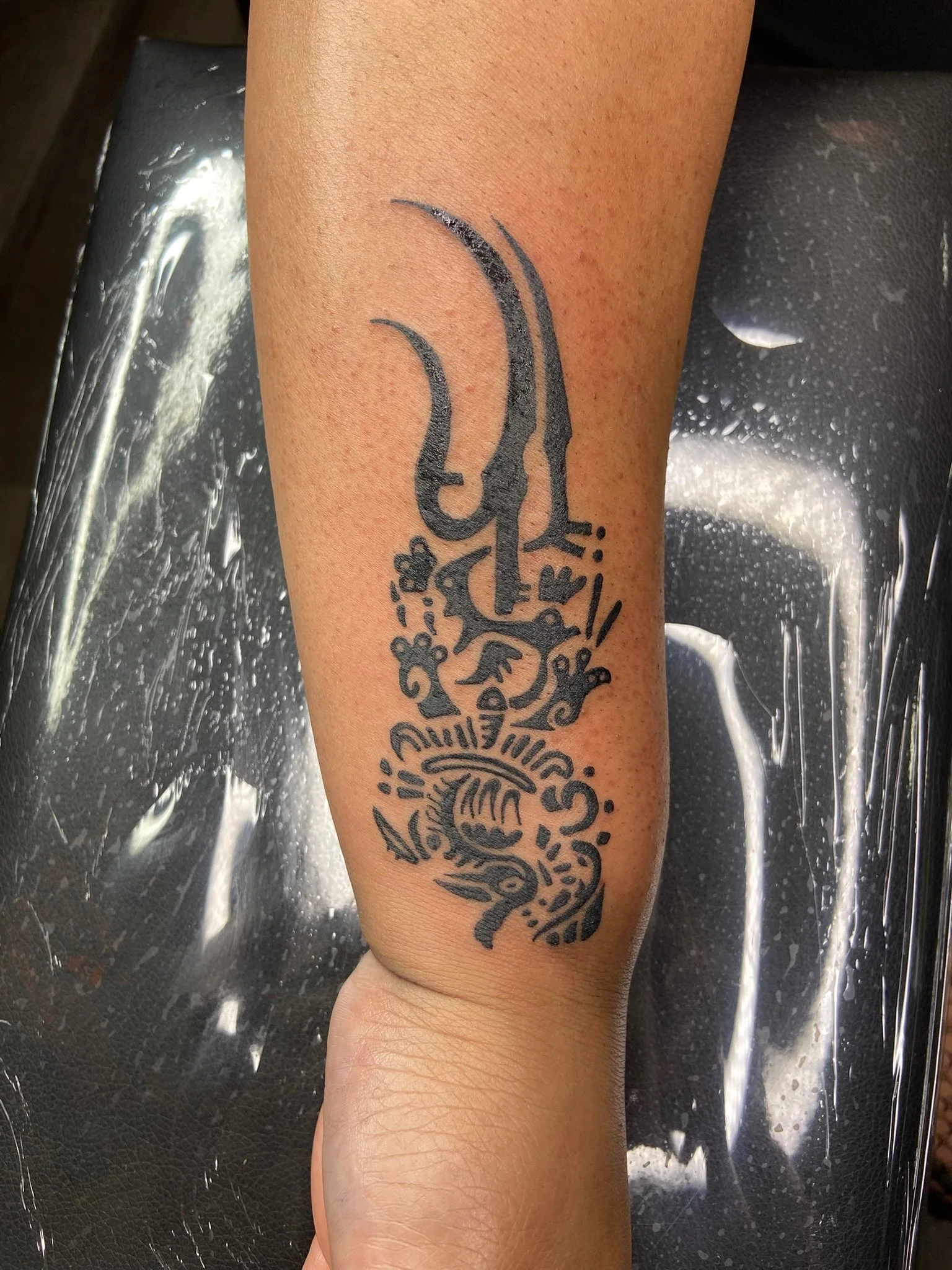 Tattoo of an intricate musical skull design on a person's calf, with detailed decoration around it.