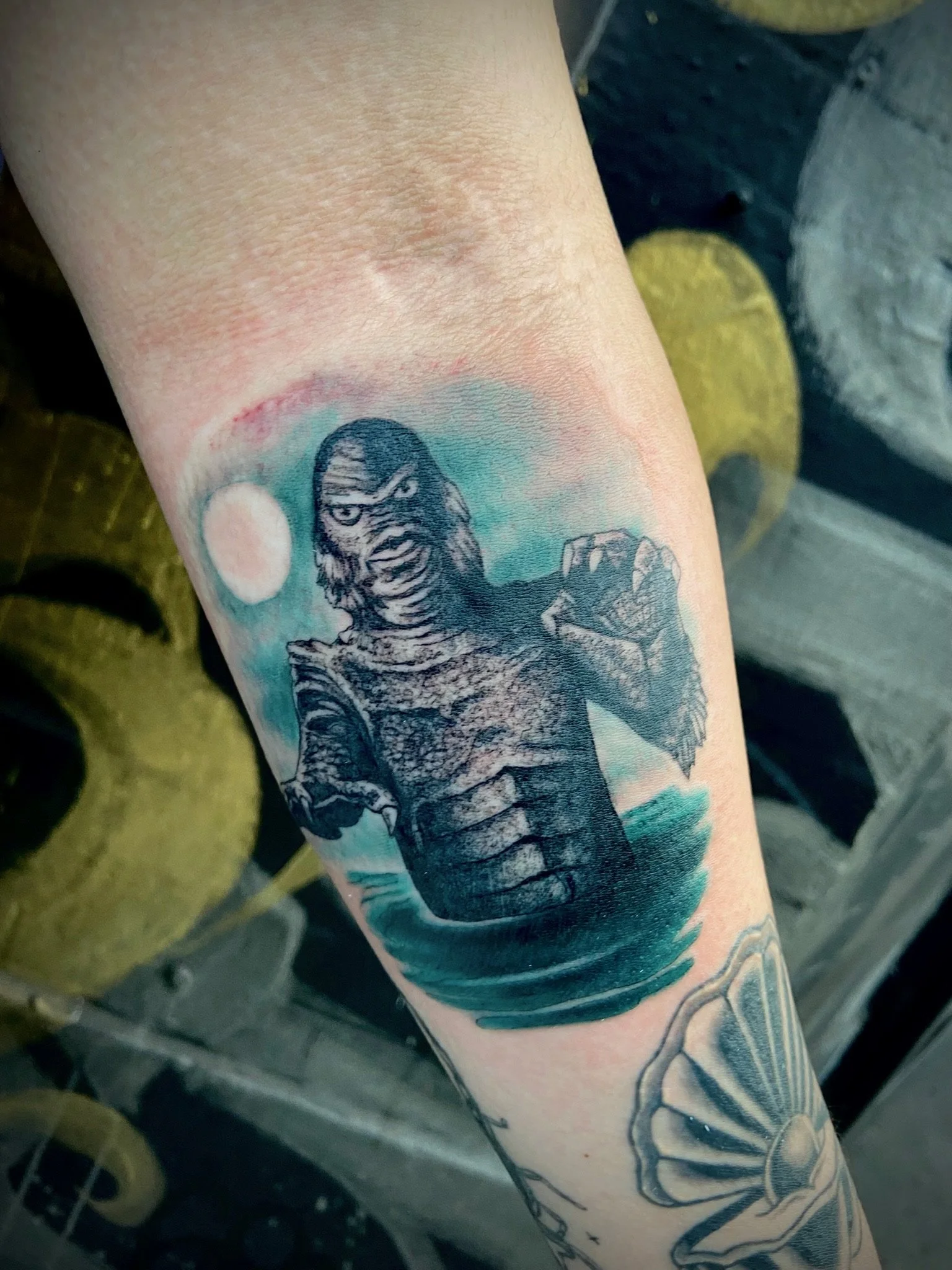 Tattoo of a gorilla on a person's arm, with colors including black, blue, and a hint of red, and a background that appears to be tattoo ink or artwork.