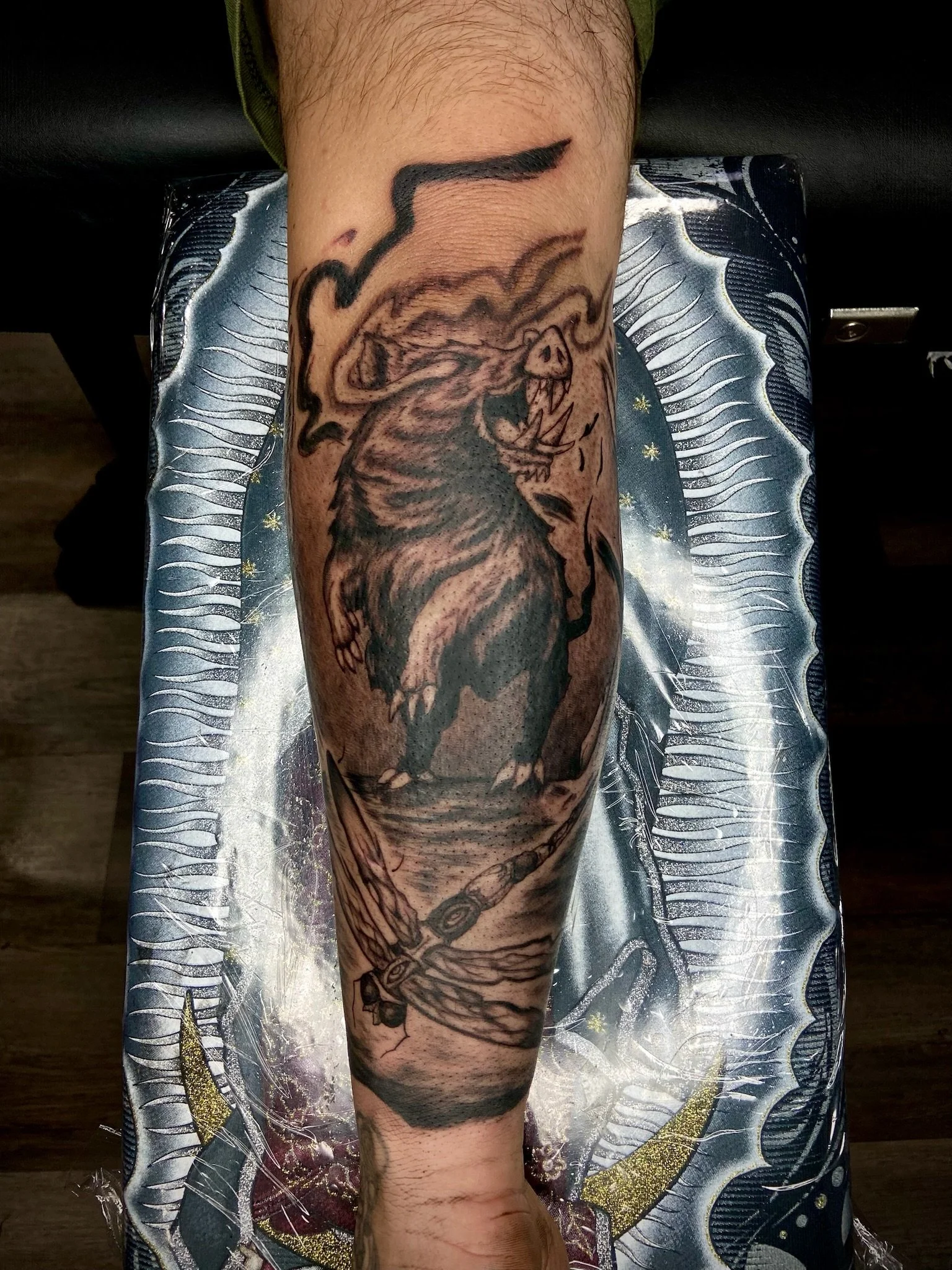 Tattoo of a fierce roaring lion on a person's arm.