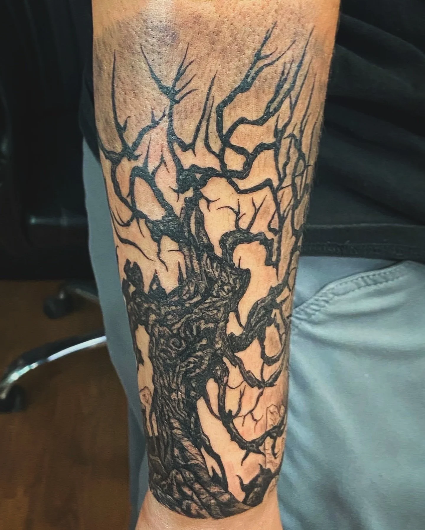 Tattoo of a leafless tree with intricate branches on a person's arm