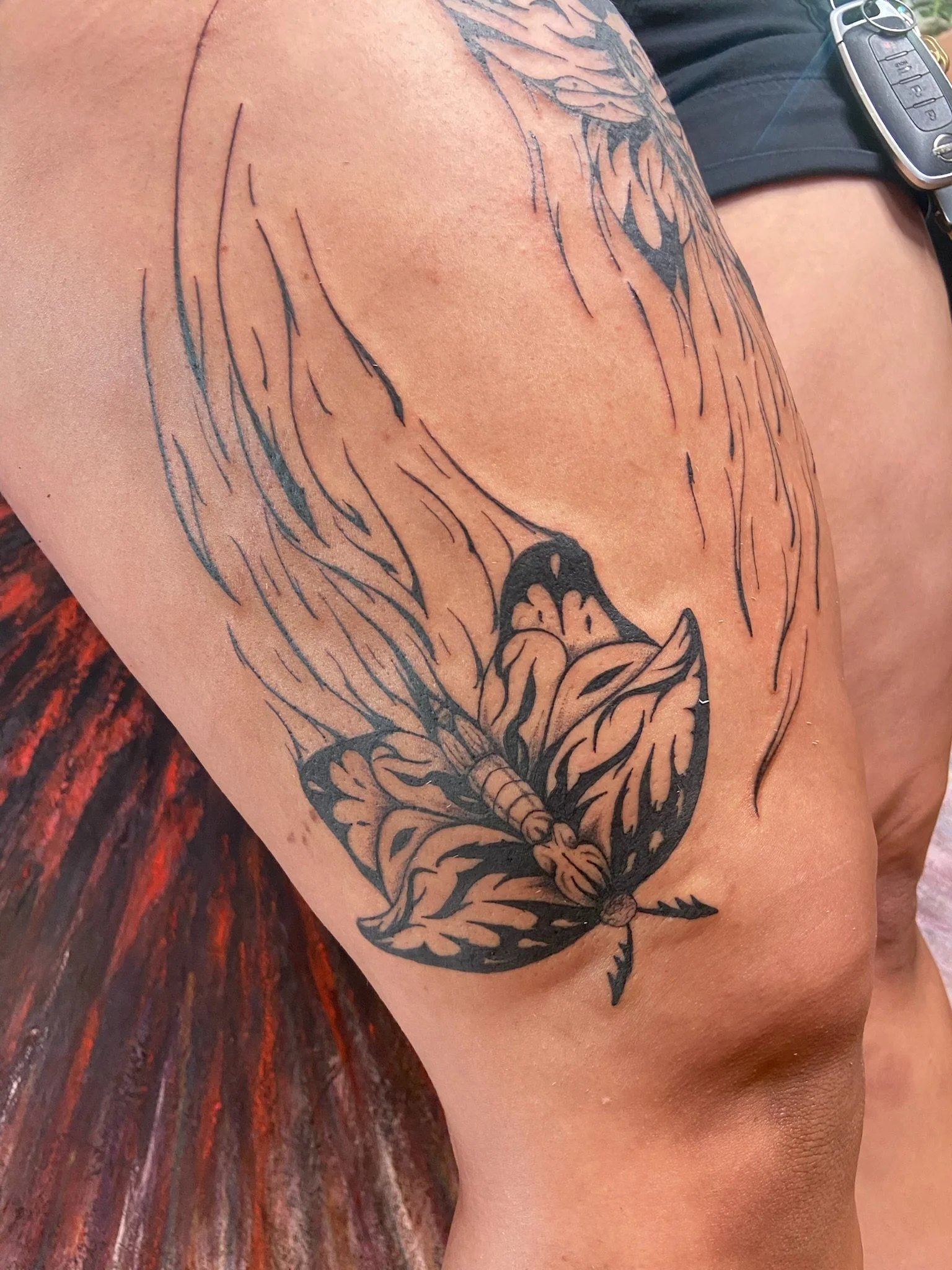 Fresh blackout tattoo of a butterfly on a person's shoulder with detailed wings and body.