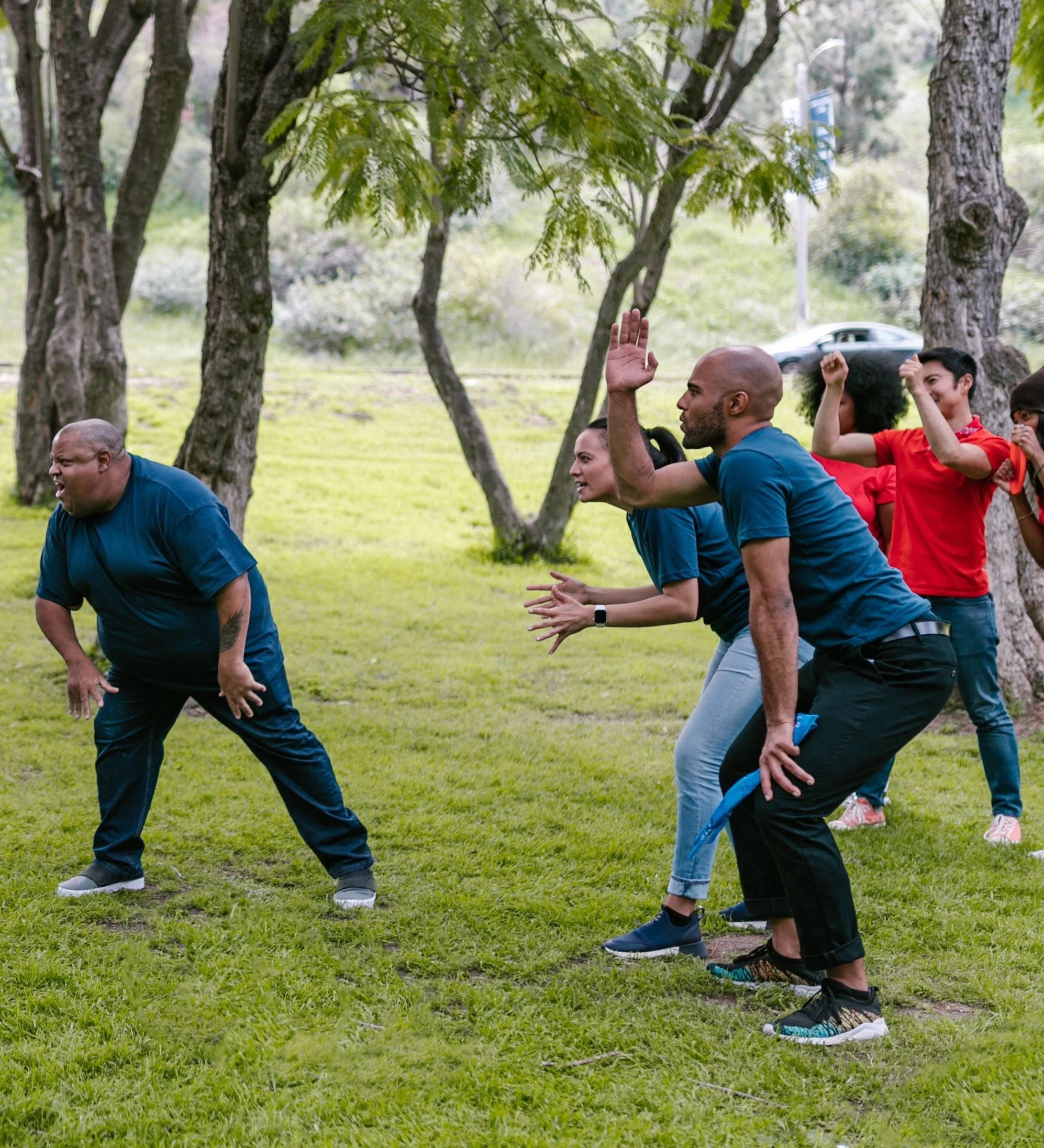 Adults taking part in a playful outdoor team-building challenge