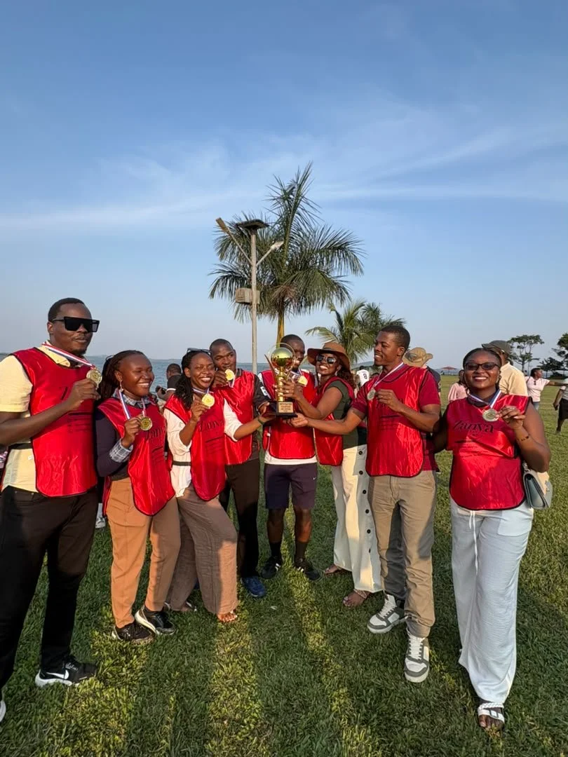 The red-bib team celebrating with medals and a trophy.