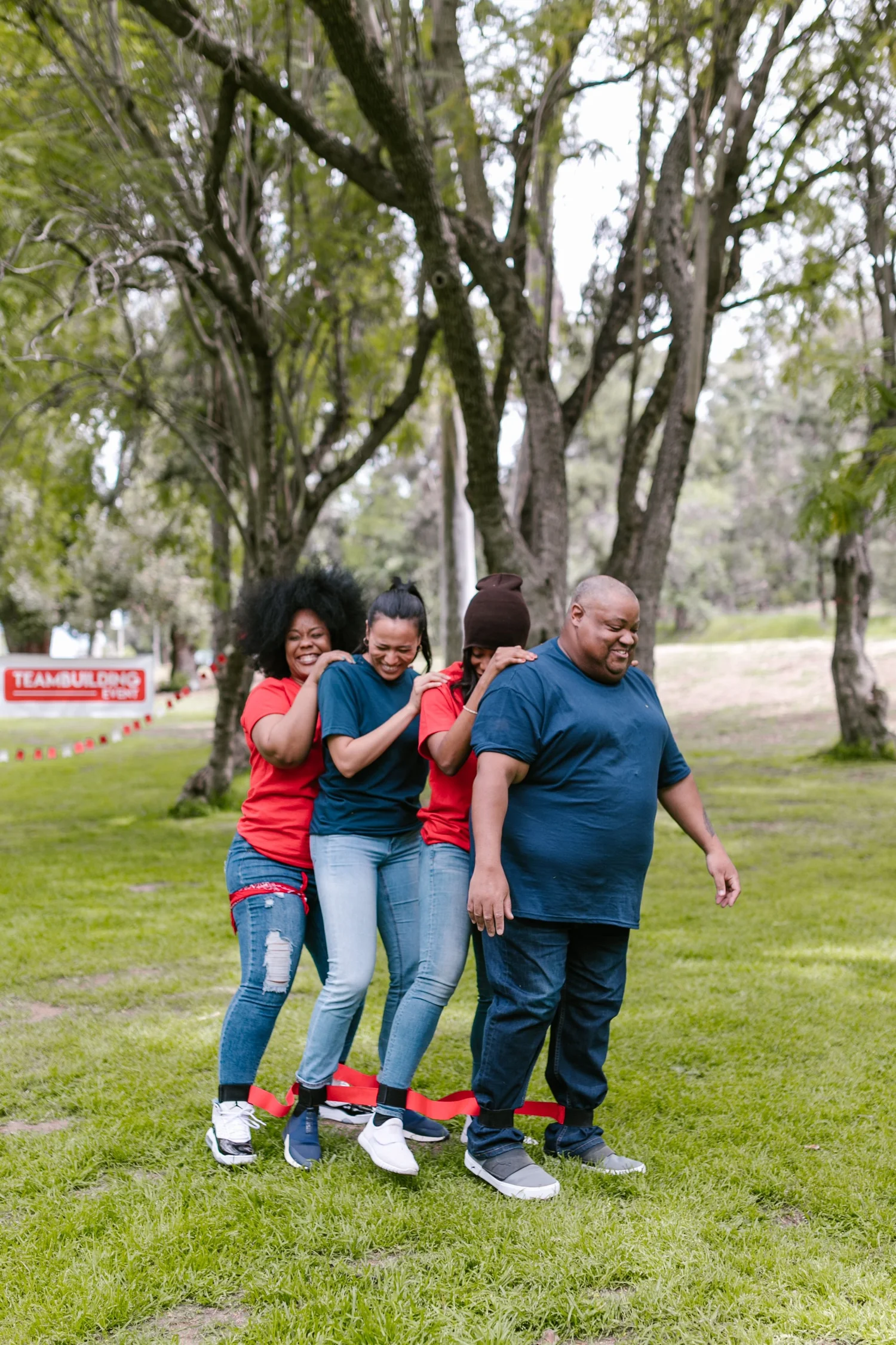 Adults coordinating their steps in a linked-leg team-building challenge