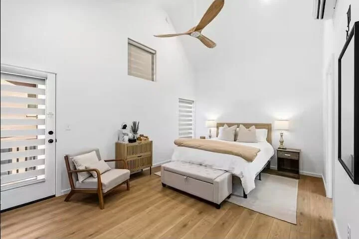 Bright queen bedroom at SoKno Haven with vaulted ceiling, private balcony door and natural light