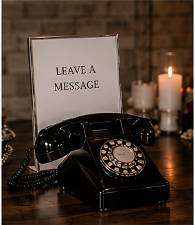 Vintage rotary phone placed in front of a sign that says 'Leave a Message', with lit candles in the background.