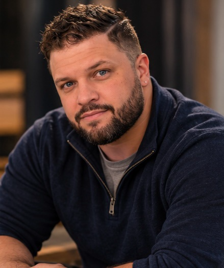Portrait of John Colin Osinski in a navy pullover