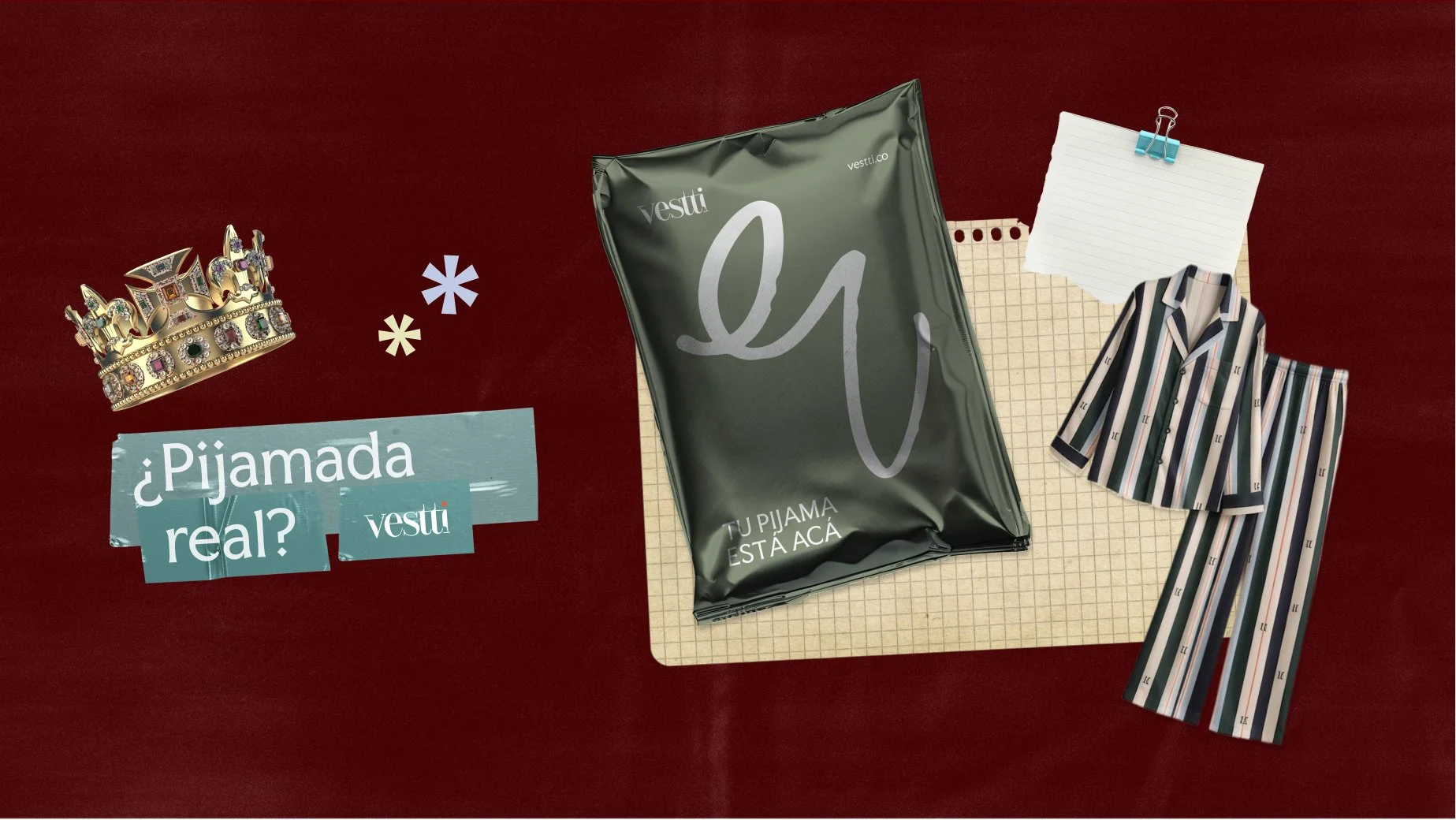 Una corona dorada adornada con gemas y una hoja de papel congancho azul, sobre una mesa de color rojo oscuro, junto a un paquete de pijama en envoltura plástica, un cuaderno con cuadrícula, y un conjunto de ropa de pijama con rayas verticales en colores beige, gris, verde y negro, y un texto que dice '¿Pijama real? vestti'.
