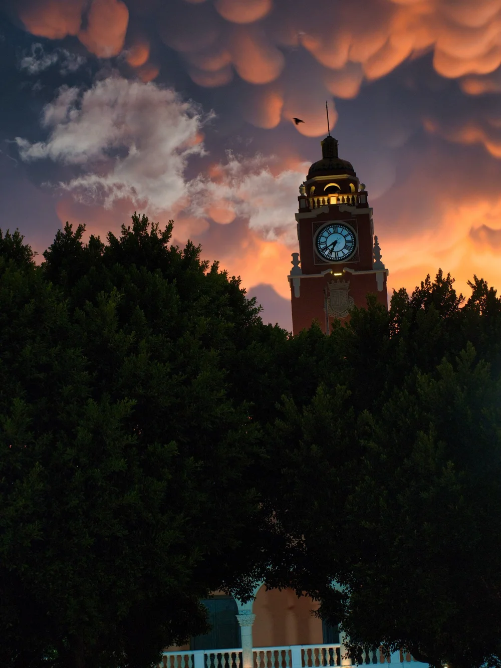 Clock tower against a dramatic dusk sky