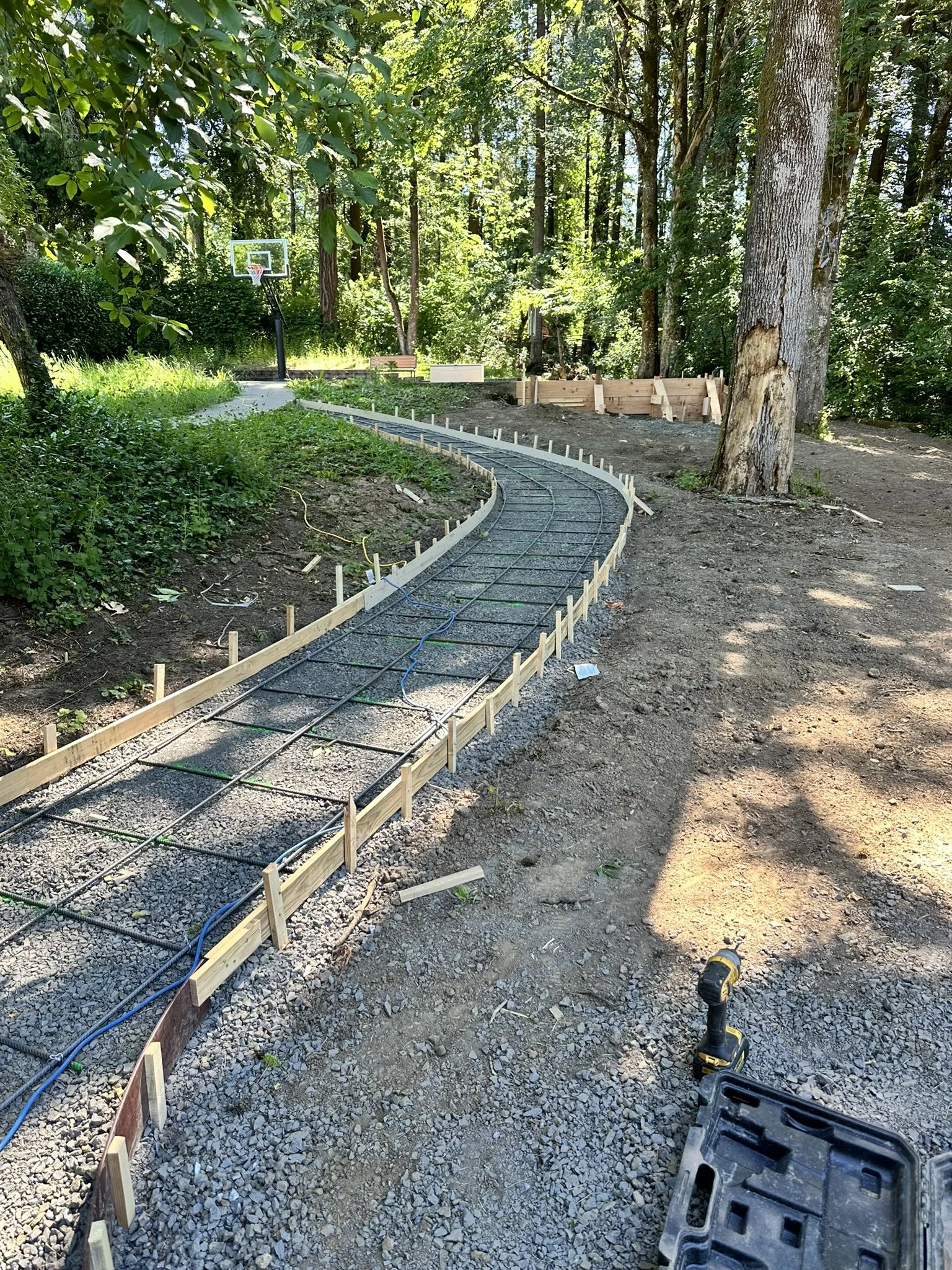Curved walkway forms and steel reinforcement prepared for a concrete pour.