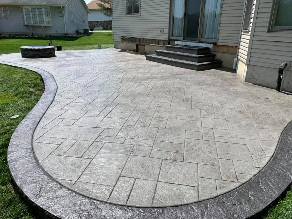 Example project photo to replace: textured concrete patio with a curved border and steps.