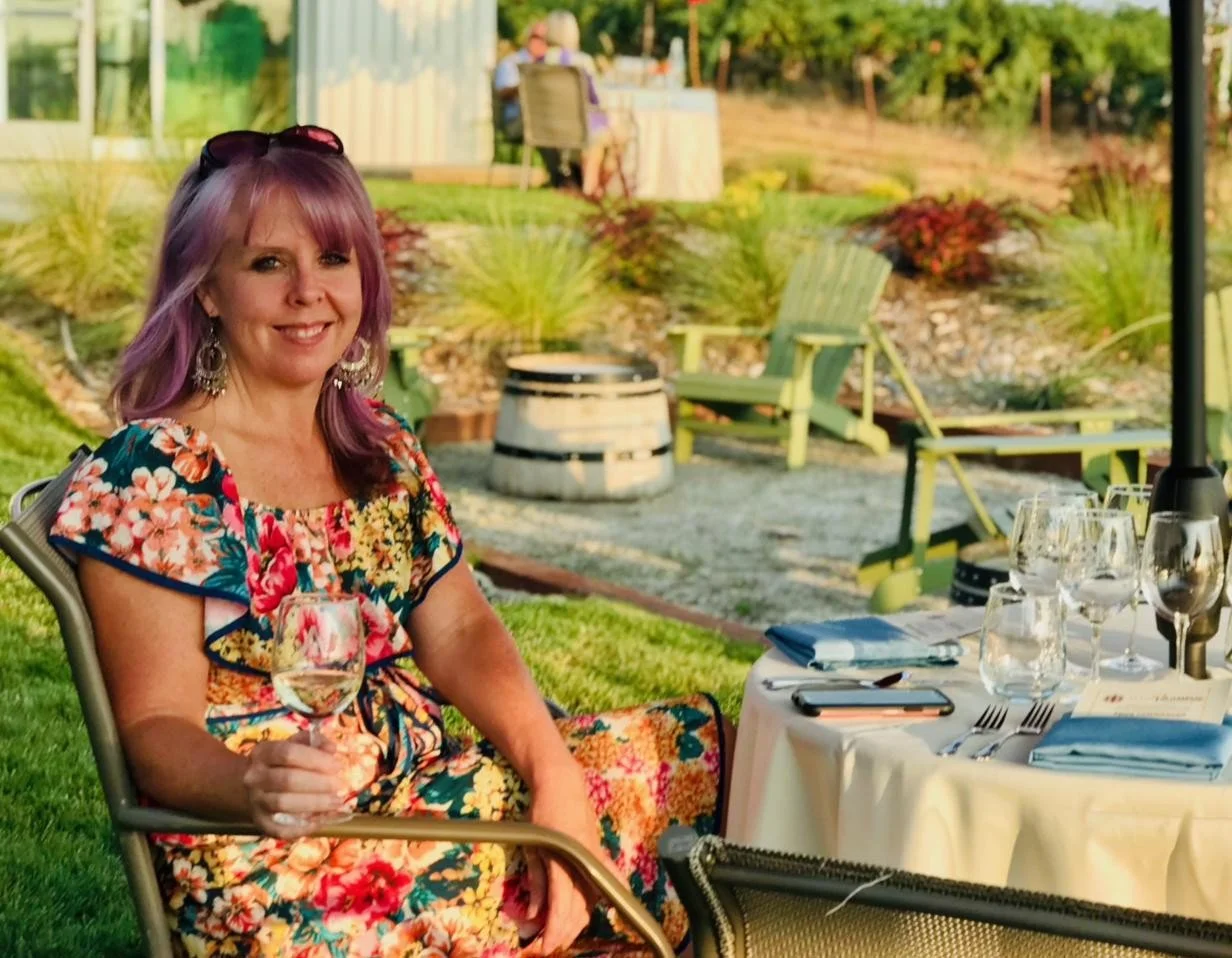 Carrie Boyle, founder of Wondria, holding a glass of white wine