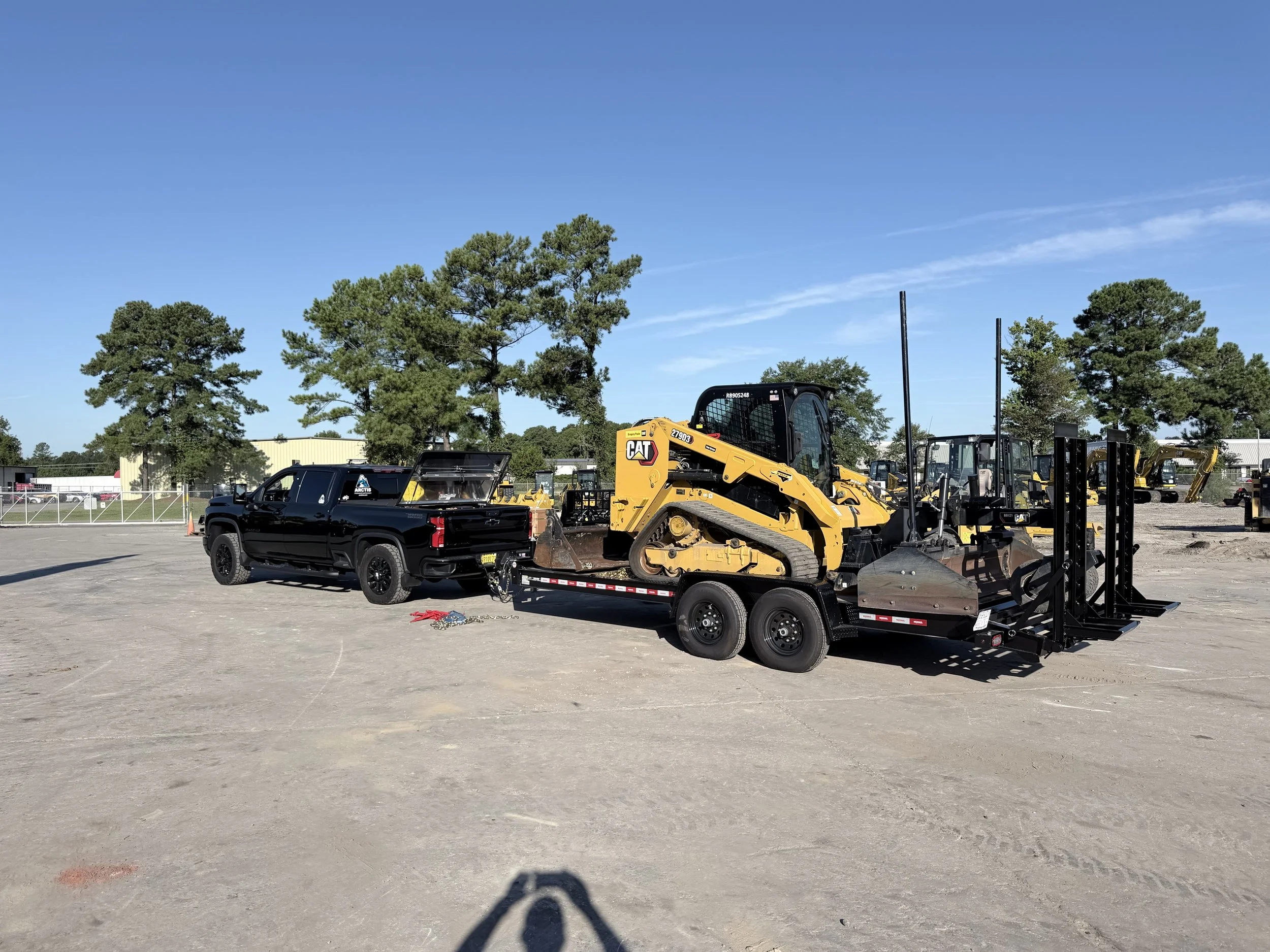 Arctis Siteworks truck and trailer carrying a compact track loader
