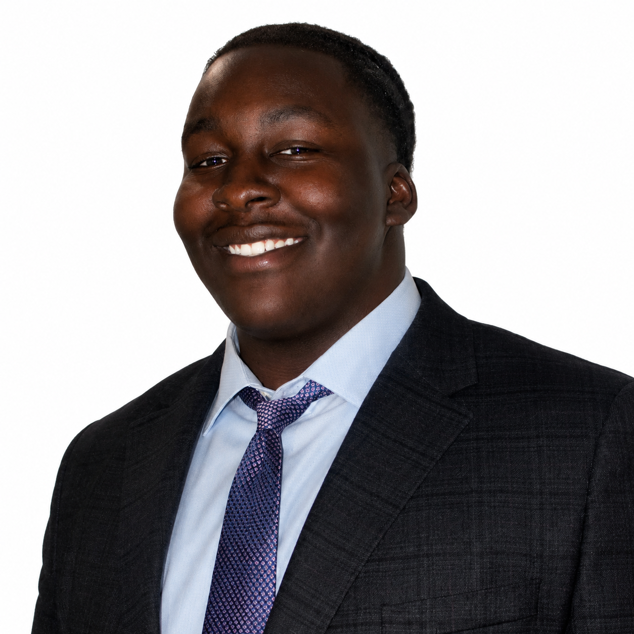 Portrait of a smiling African American man in a suit and tie, against a white background.