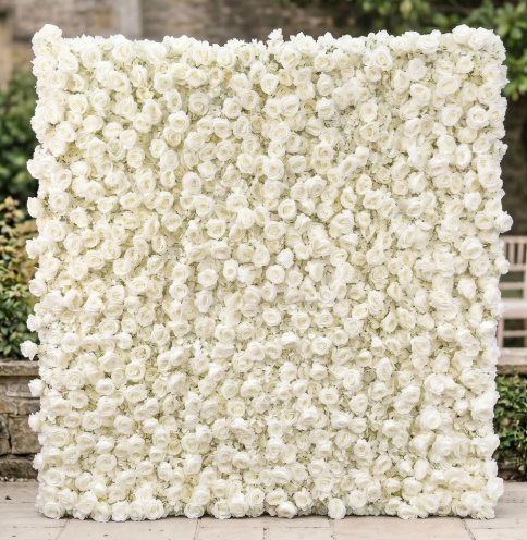 A large rectangular backdrop made entirely of white roses, used for a decorative or event setting.