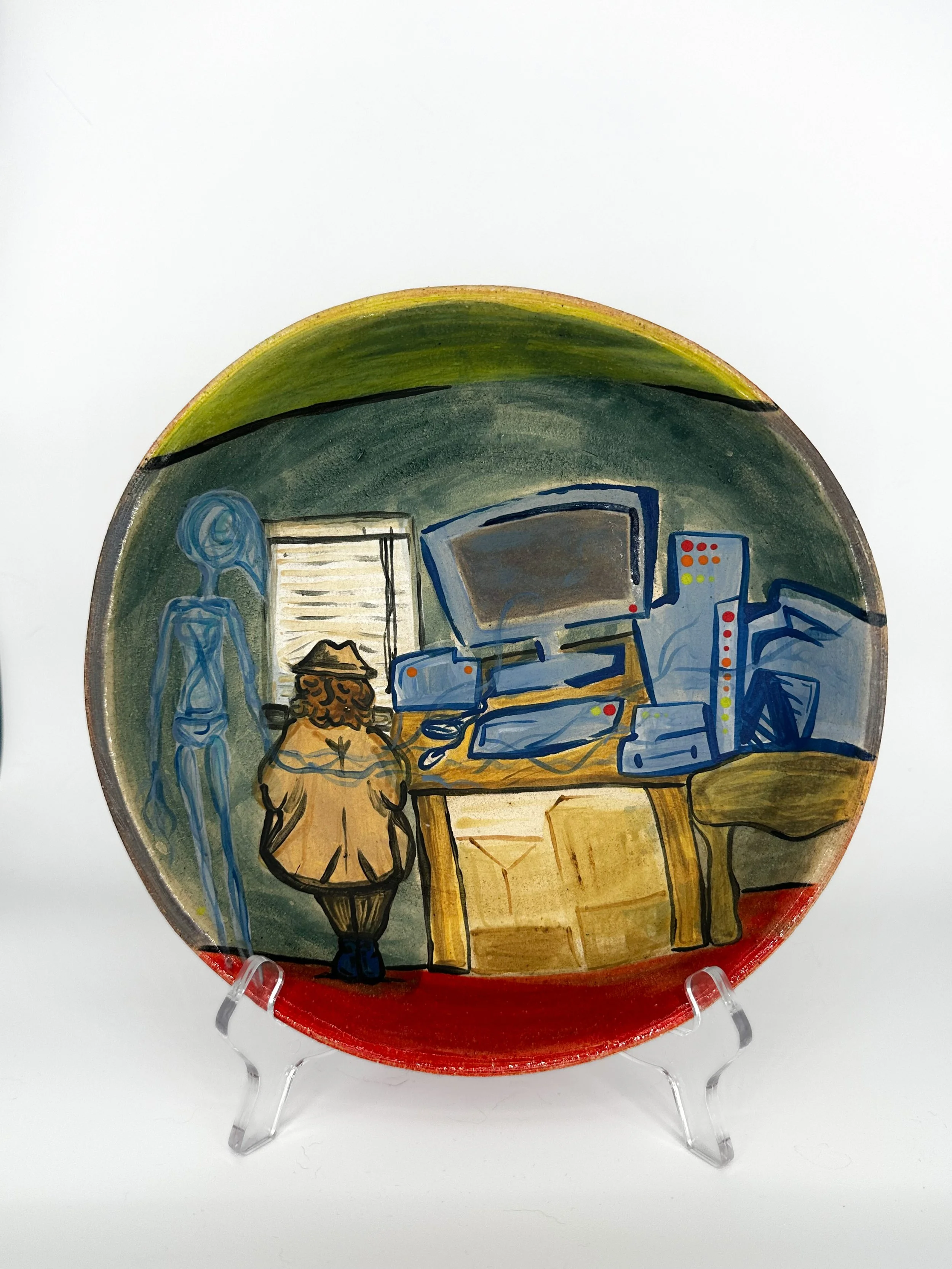 Decorative plate with a painted scene of a person with a hat sitting at a table in a room with a television, computer, and window, viewed on a white background.