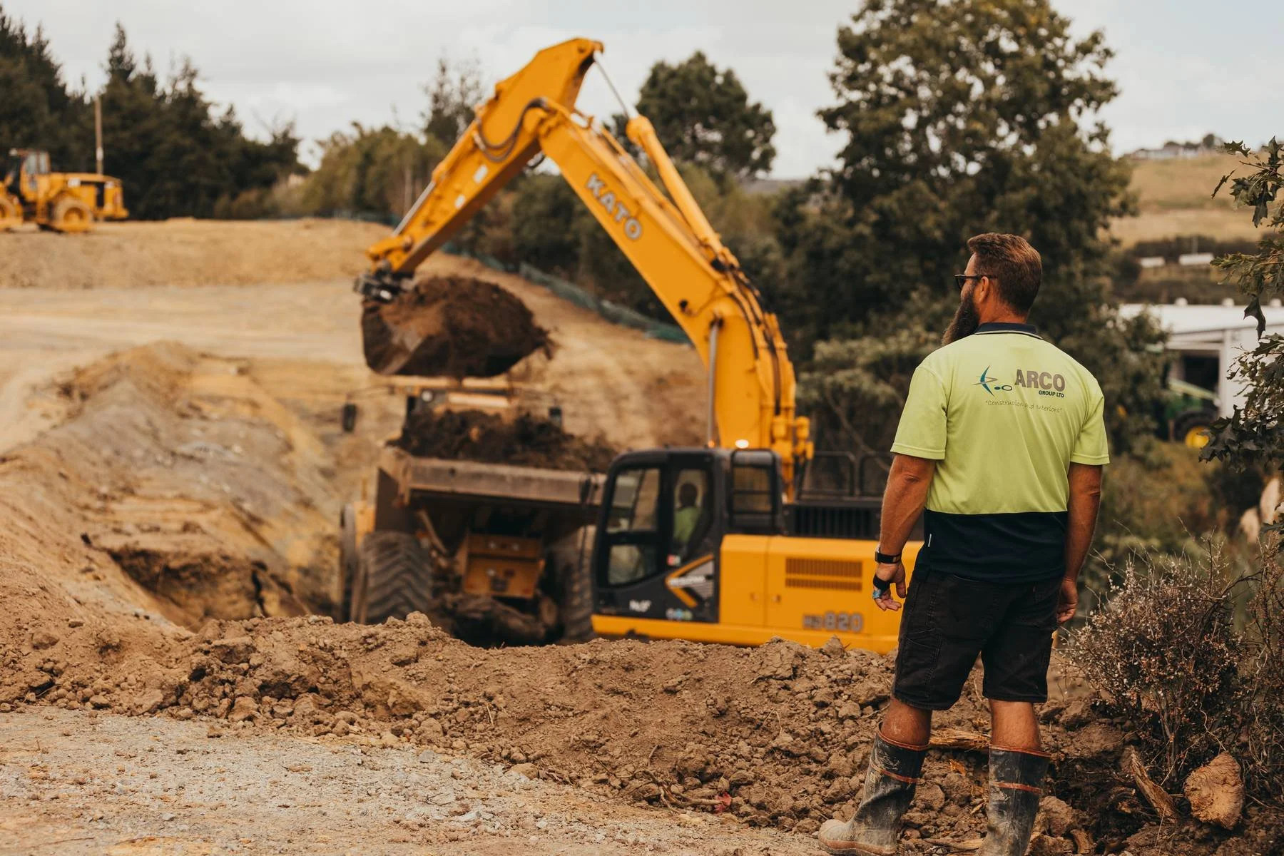 Construction worker look at digger on site
