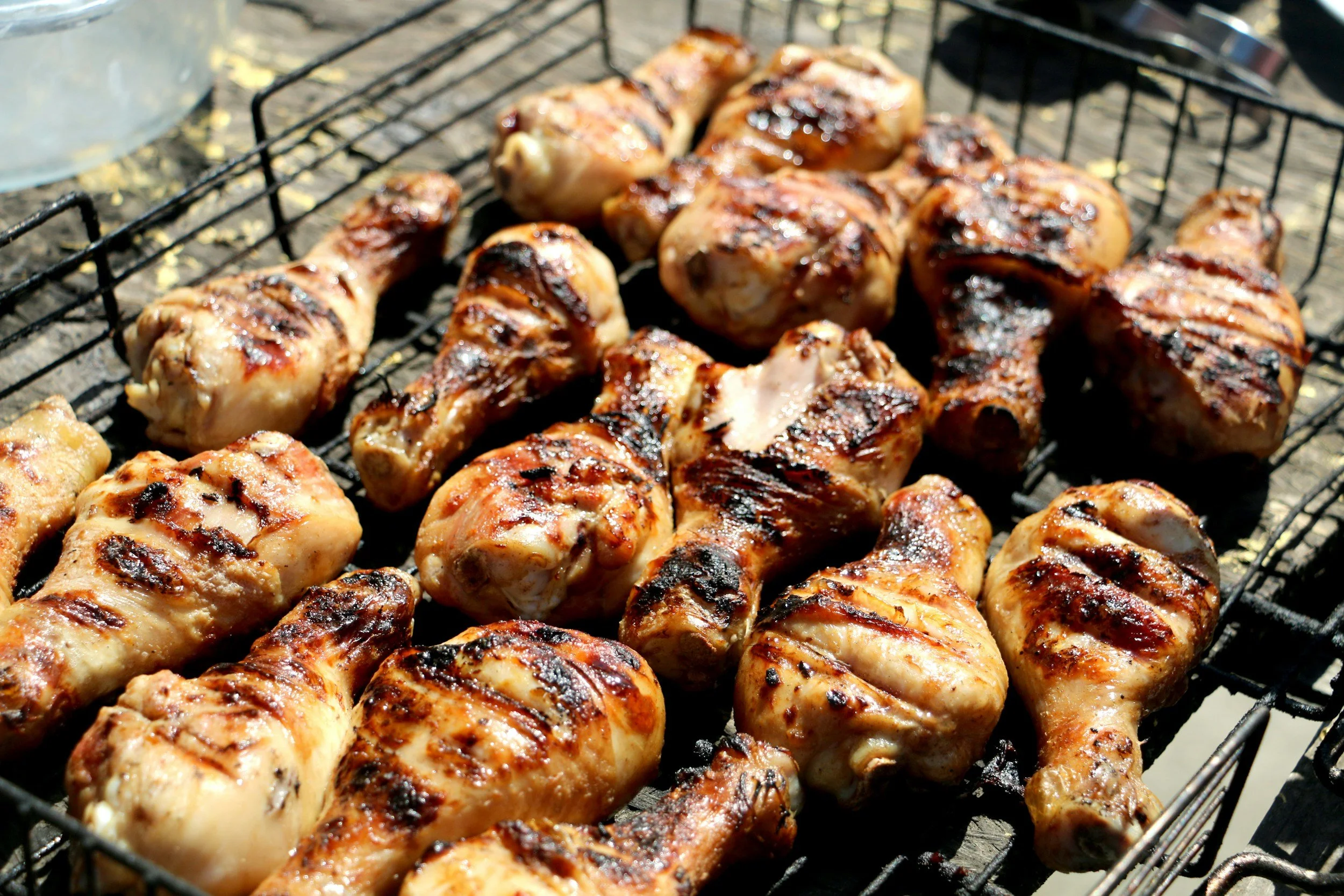 Grilled chicken pieces with grill marks on a barbecue grill.
