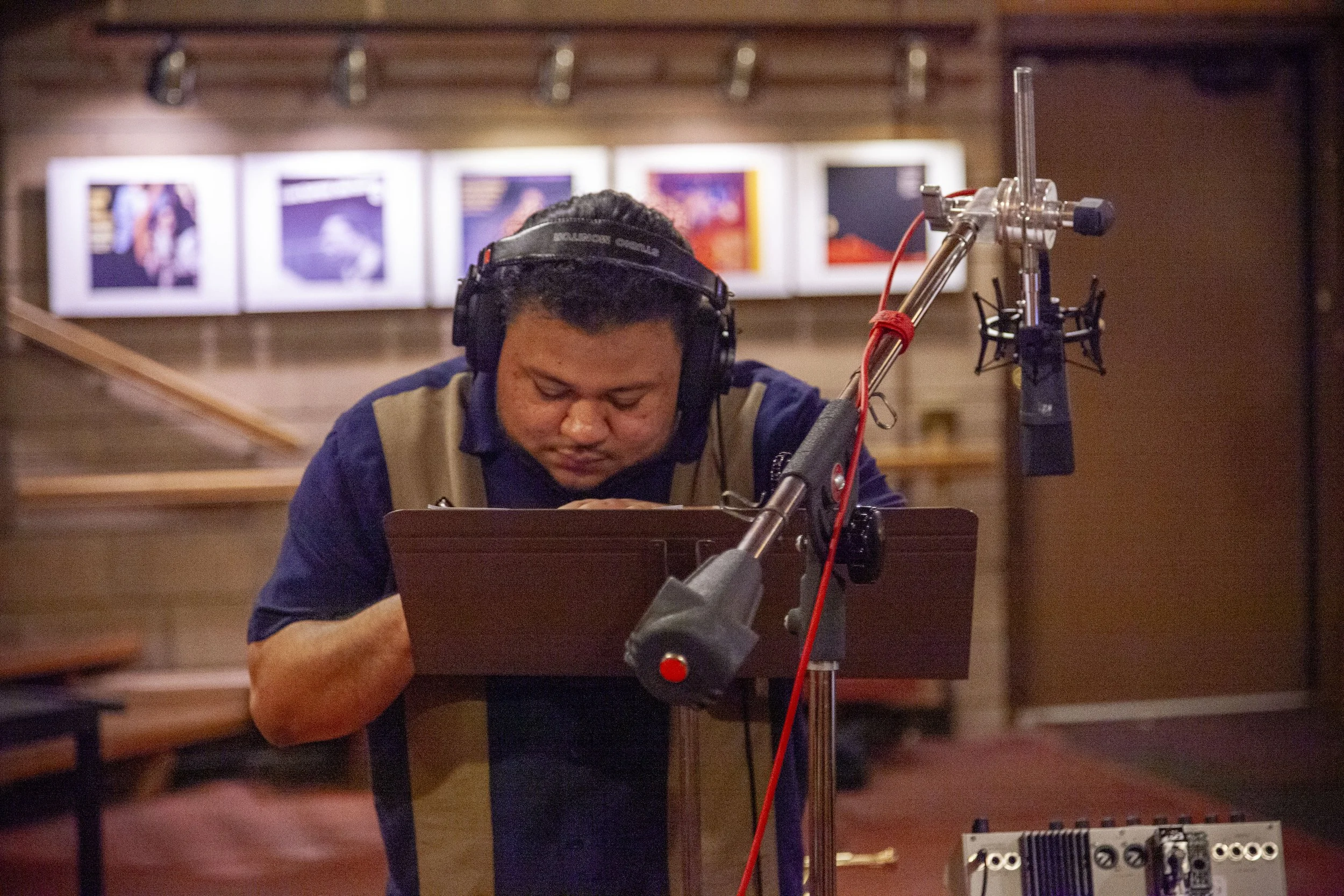 Blackhawk Quintet @ Van Gelder Studios. Engelwood Cliffs, NJ. A man with headphones working in a recording studio with walls decorated with framed pictures.