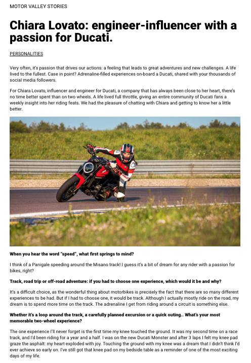 A woman in a racing suit riding a Ducati motorcycle on a race track with a grassy background.