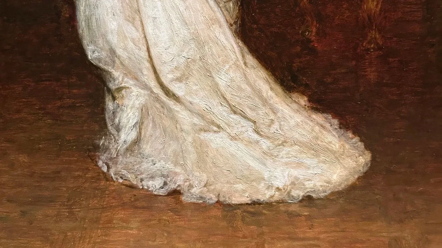 Zoomed in detail of a woman’s white dress trailing behind her on a wooden parquet floor from a classical 19th century European painting.