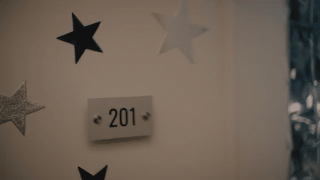 Decorated wall with black, white, and silver stars and a small plaque with the number 201.
