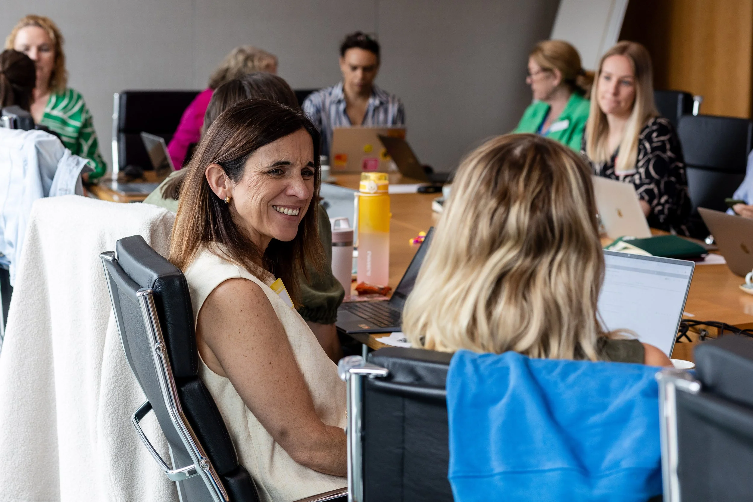 A smiling person in conversation at a coworking table