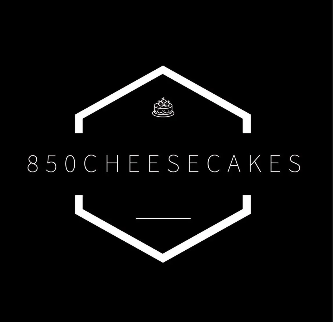 Black background logo with a white outline of a house, featuring a small cake icon at the top. The text '850 CHEESECAKES' is centered within the house outline.