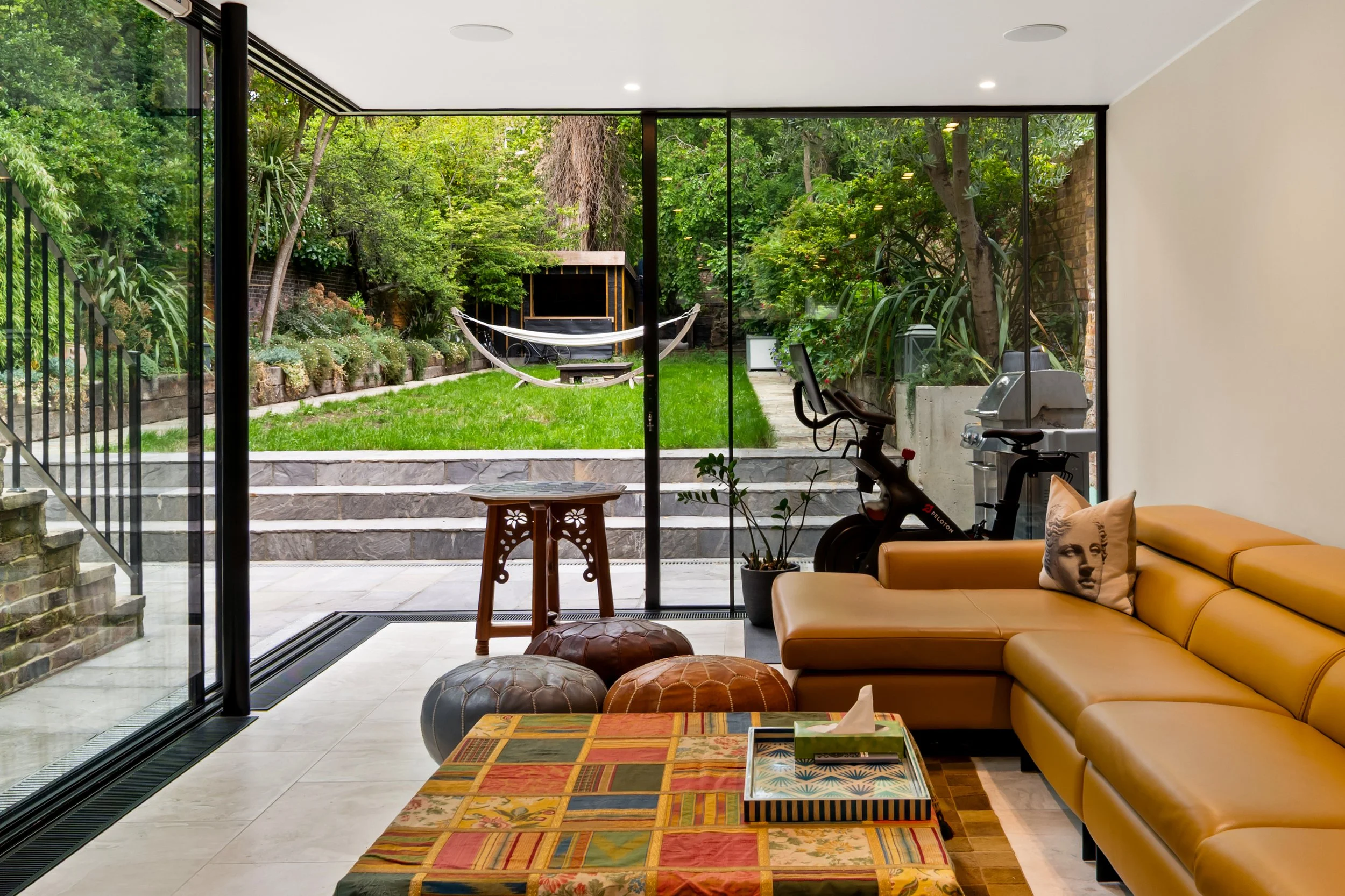 Interior view looking out through corner glazing to garden of Maida Vale 1 house