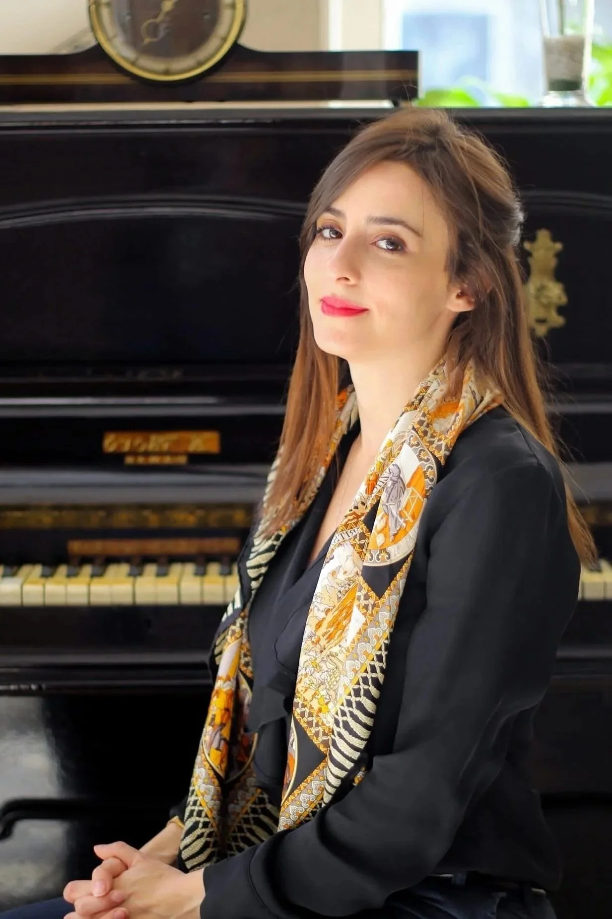 Sarah Lapis Lazuli, seascape painter, sitting in front of a piano