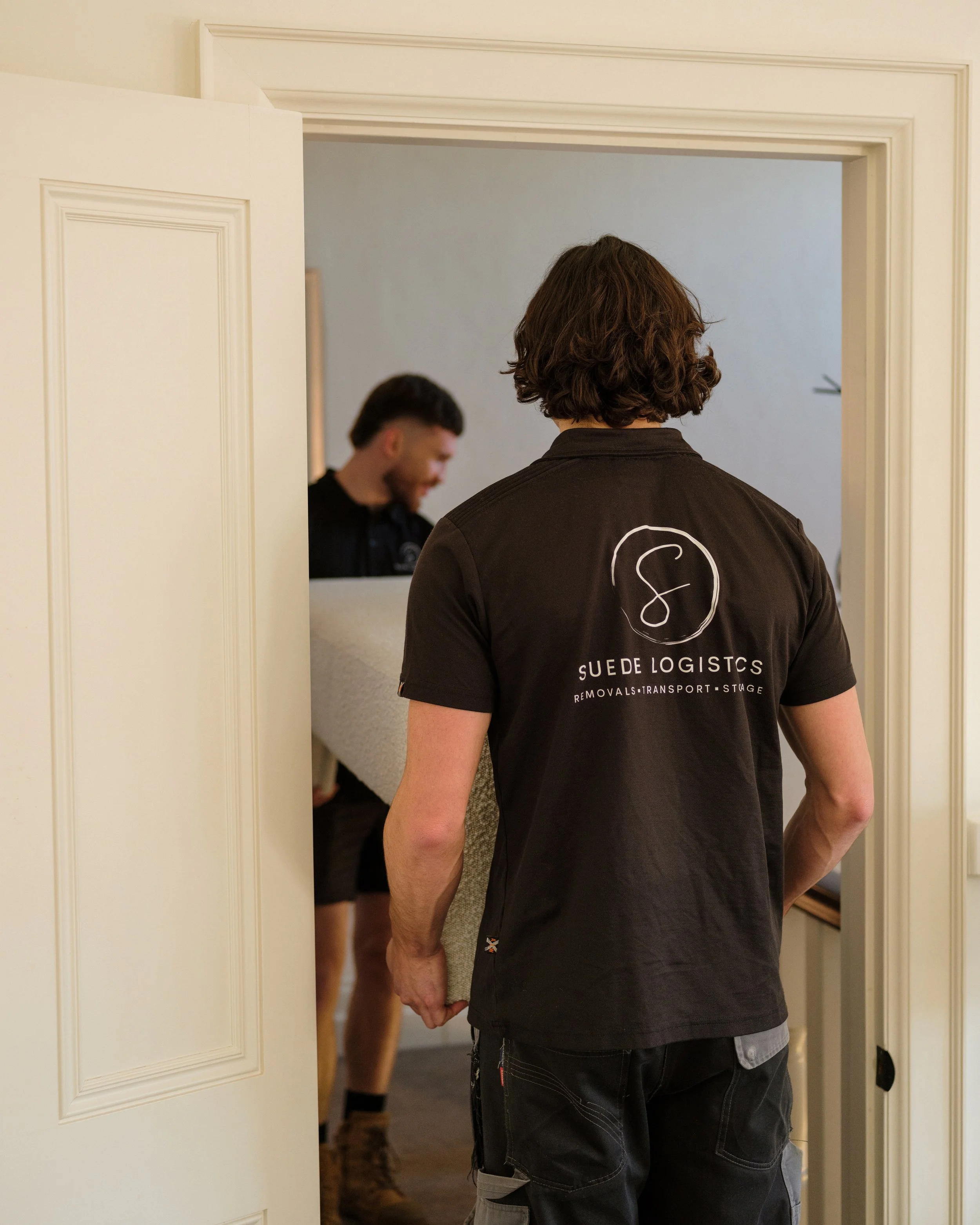 Suede Logistics removalists carrying furniture into a home during a Melbourne house move