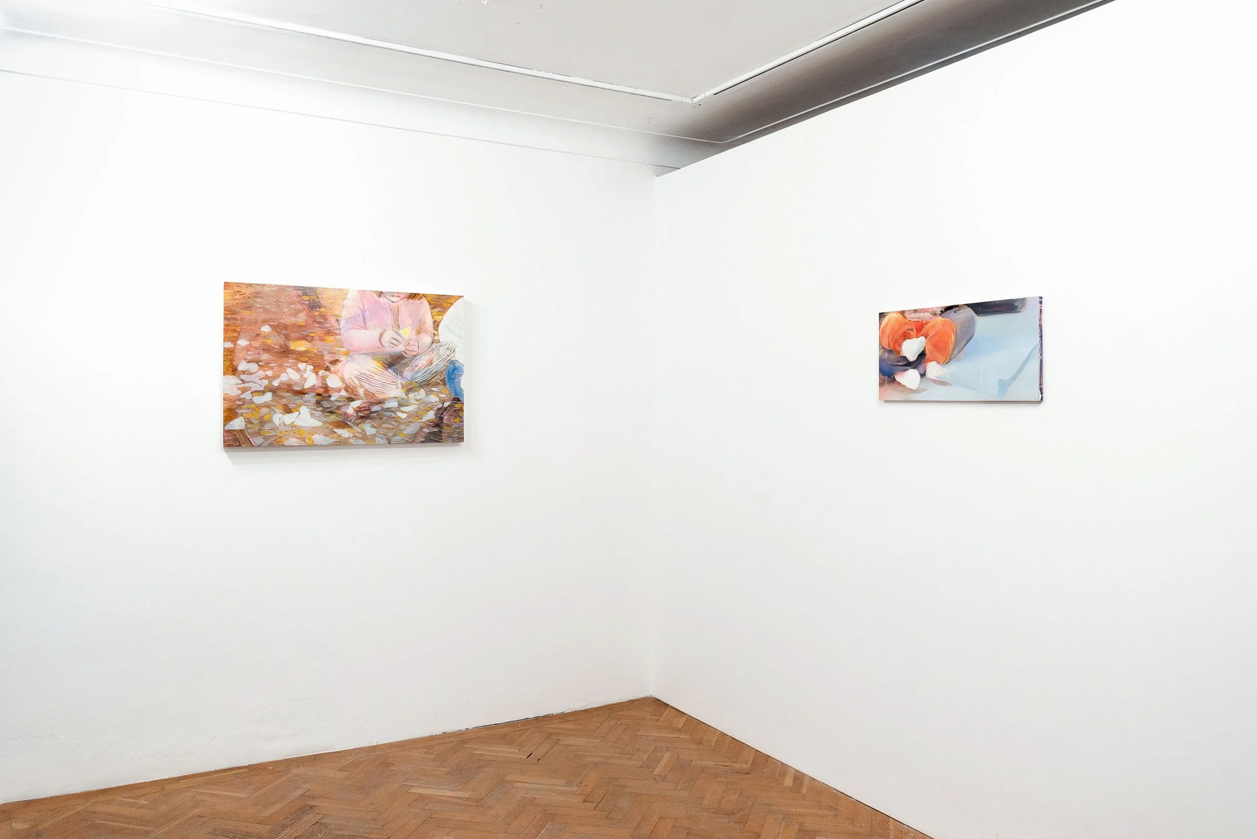 Art gallery with two paintings hanging on a white wall, wooden floor, and ceiling with visible molding.
