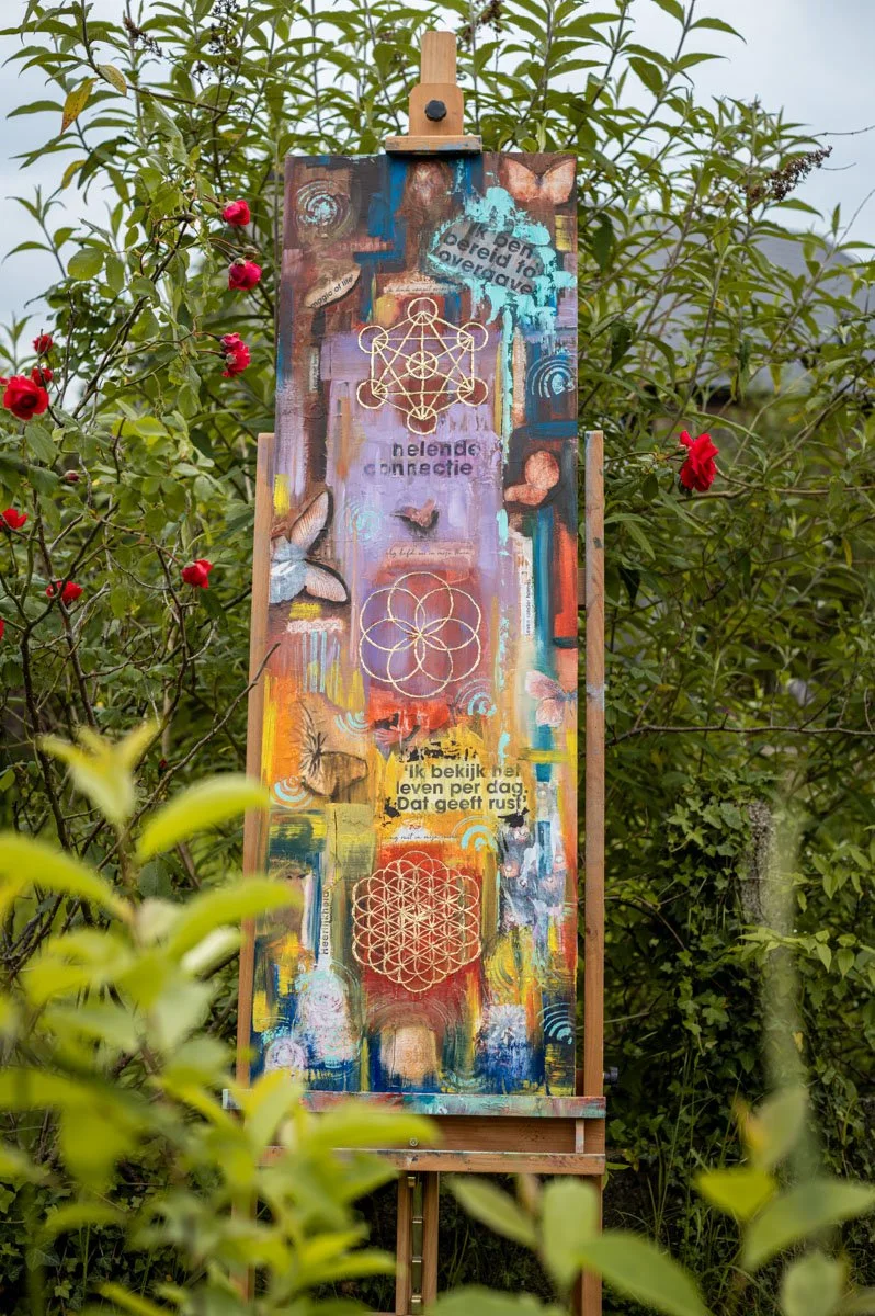 Een kleurrijk kunstwerk op een schildersezel van Martine Beyers.