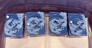 Chocolate-dipped Rice Krispies treats decorated with blue ocean waves for Shark Week celebration.