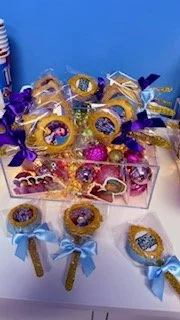 Assorted handcrafted Luna Creations treats with colorful K-pop demon hunter-inspired designs for a birthday-celebration.