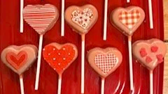 Heart-shaped Valentine's Day treats decorated in red and white designs, created for a children's theater class celebration.