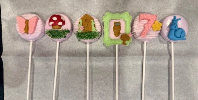 Handcrafted fairy-themed cake pops with whimsical pastel details for a seventh birthday celebration.