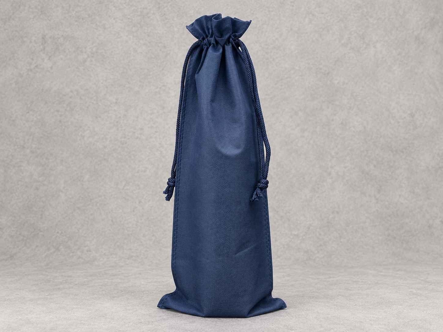Blue drawstring bag standing upright on a light textured background.