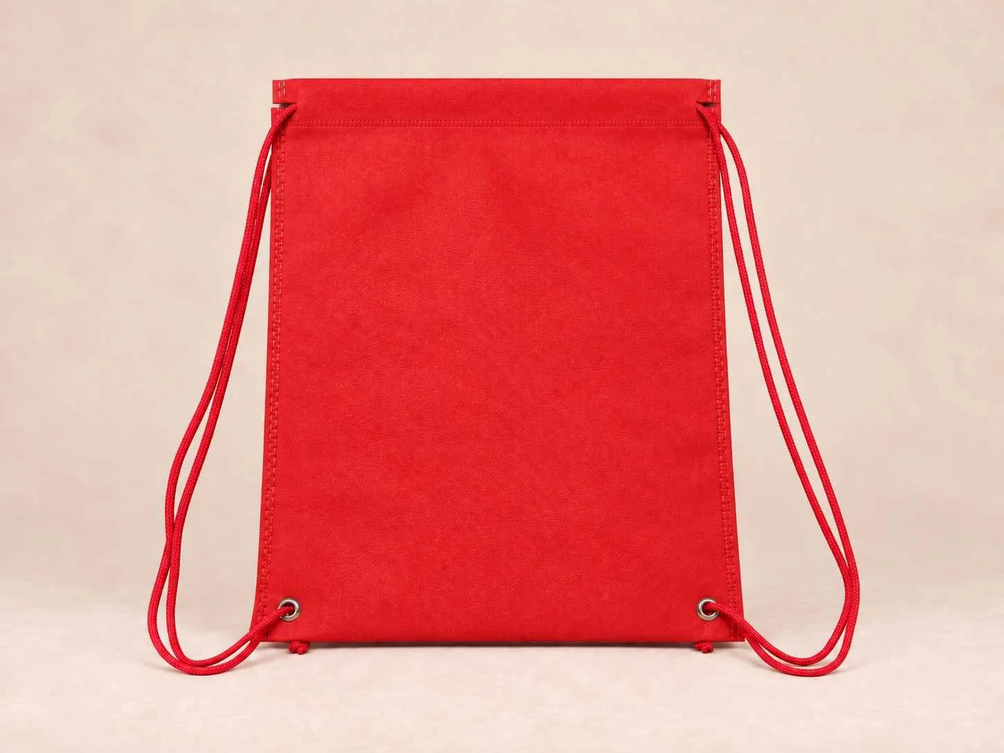 Tula plana de cambre reutilizable color rojo sobre un fondo neutro. 