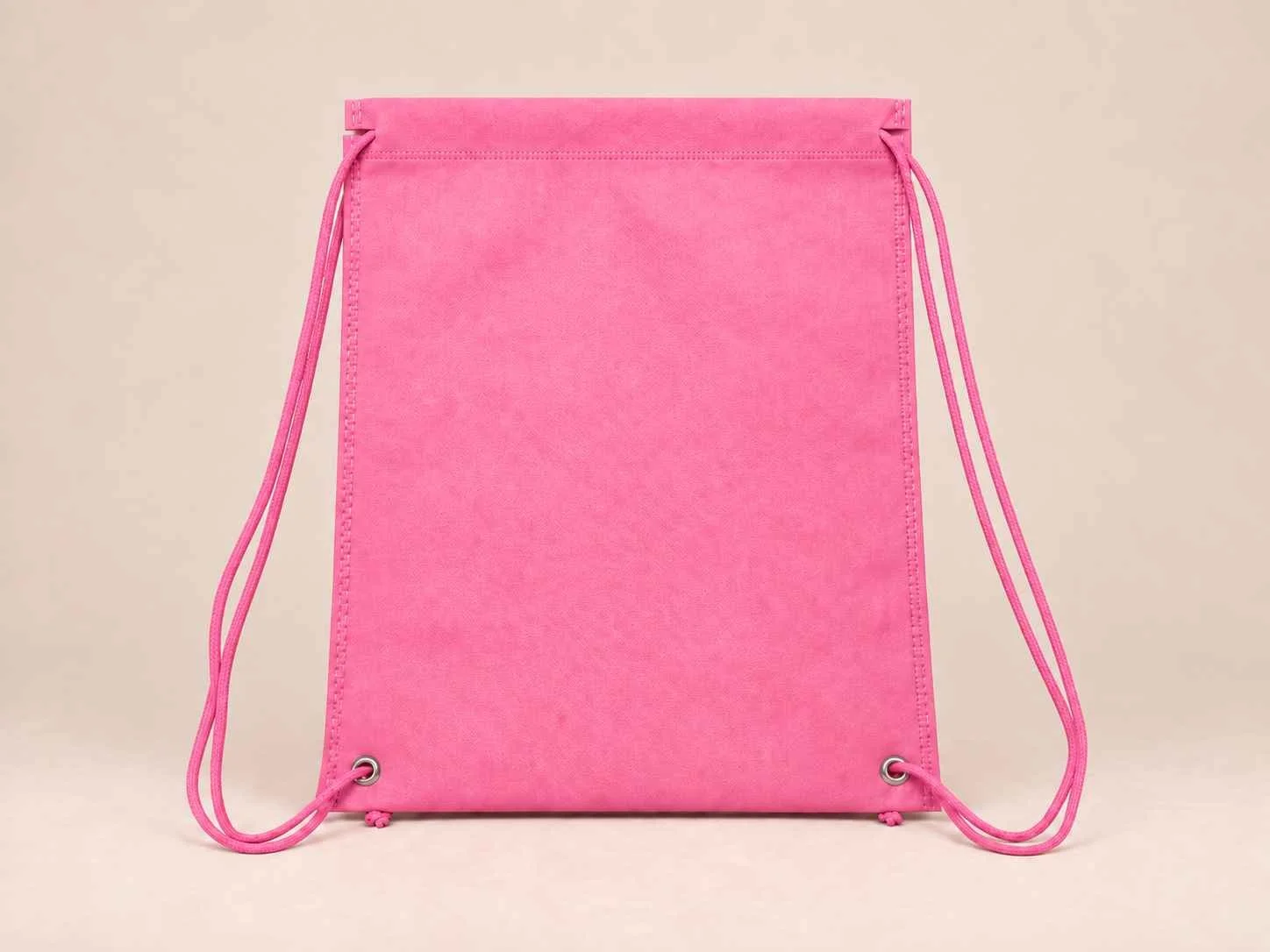 Tula plana de cambre reutilizable color rosado sobre un fondo neutro. 