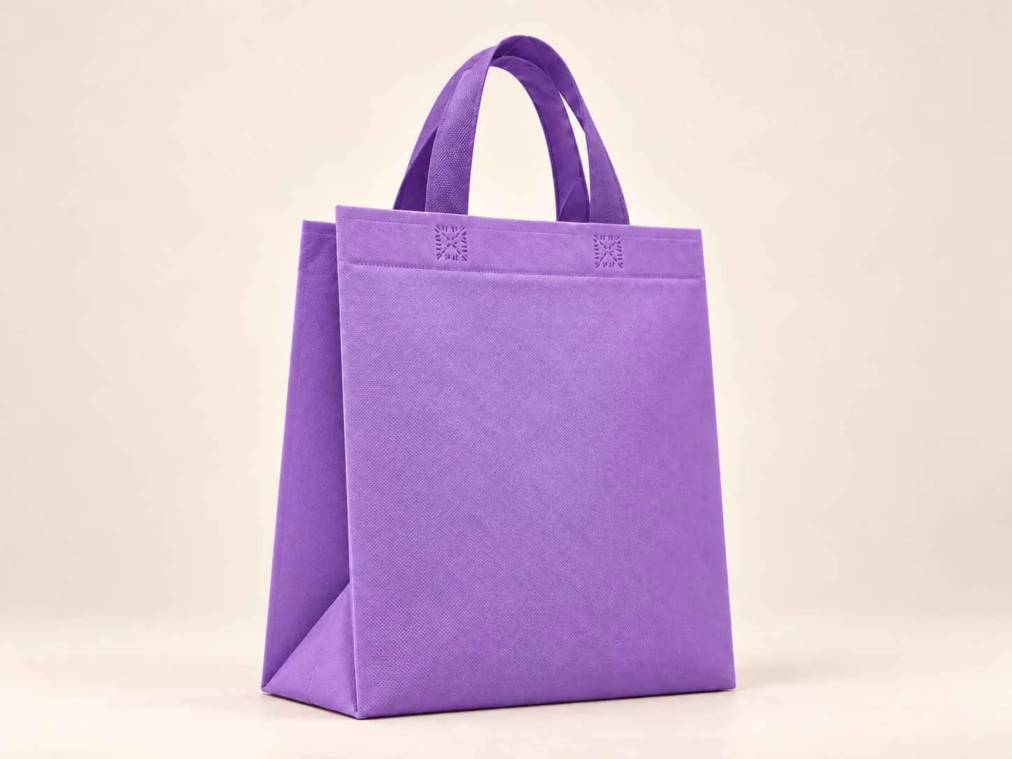Bolsa 3 fuelles de cambrel reutilizable color morado con manijas sobre un fondo neutro.