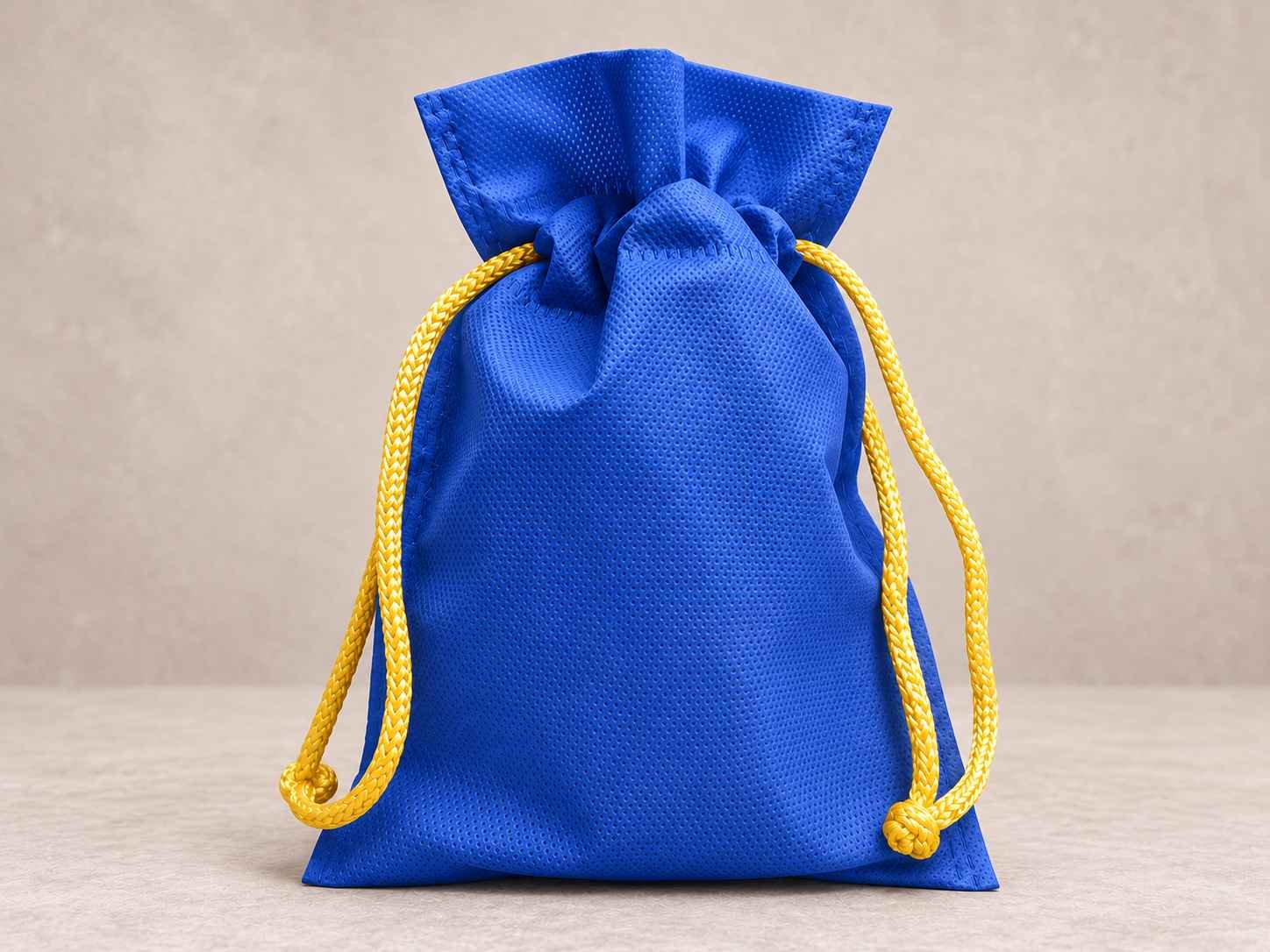 Bolsa de cambrel reutilizable caramelo color azul rey con cordón amarillo sobre un fondo neutro.