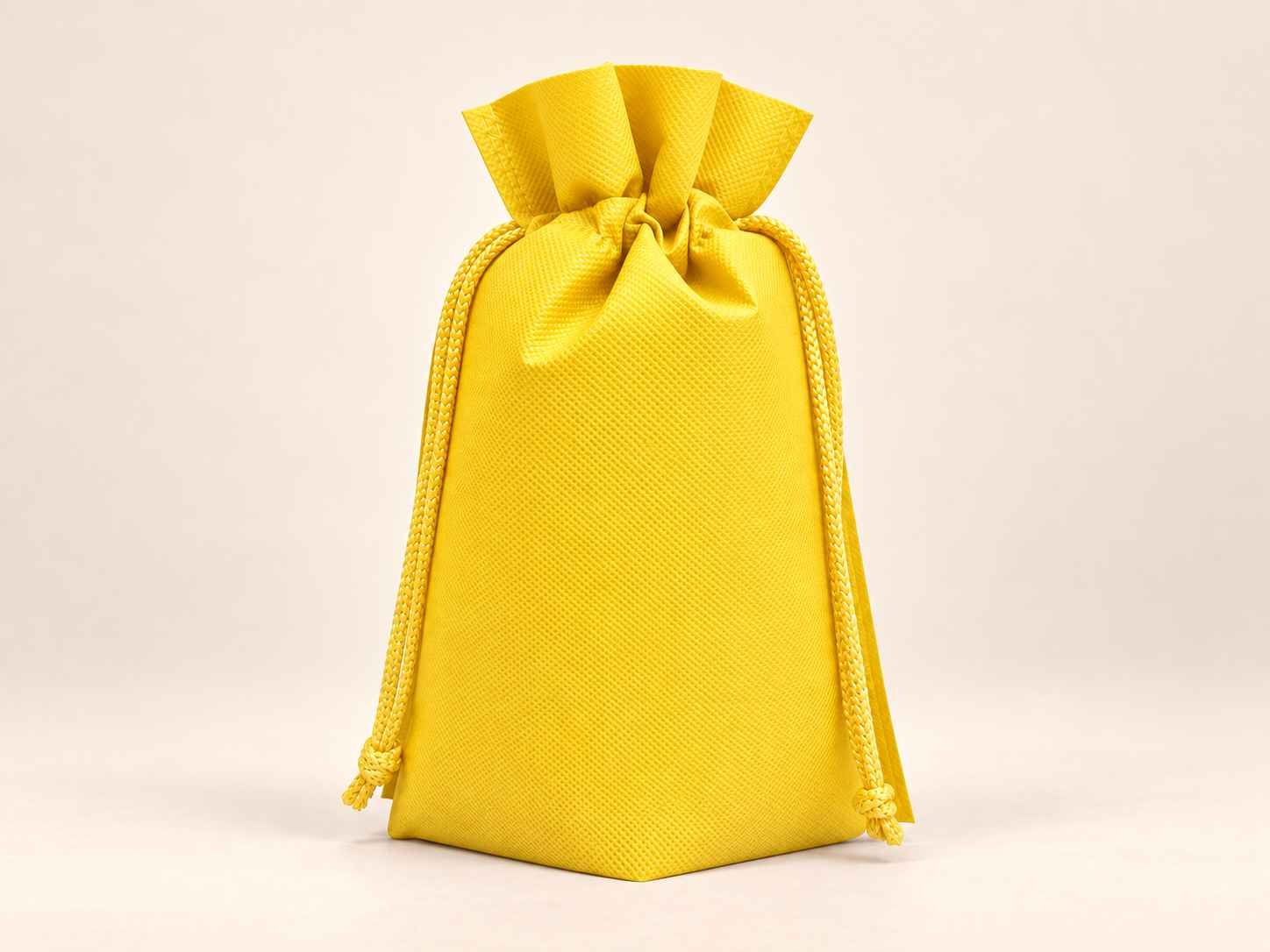 Bolsa en cambrel caramelo fuelle abajo reutilizable color amarilla con cordones sobre un fondo neutro.