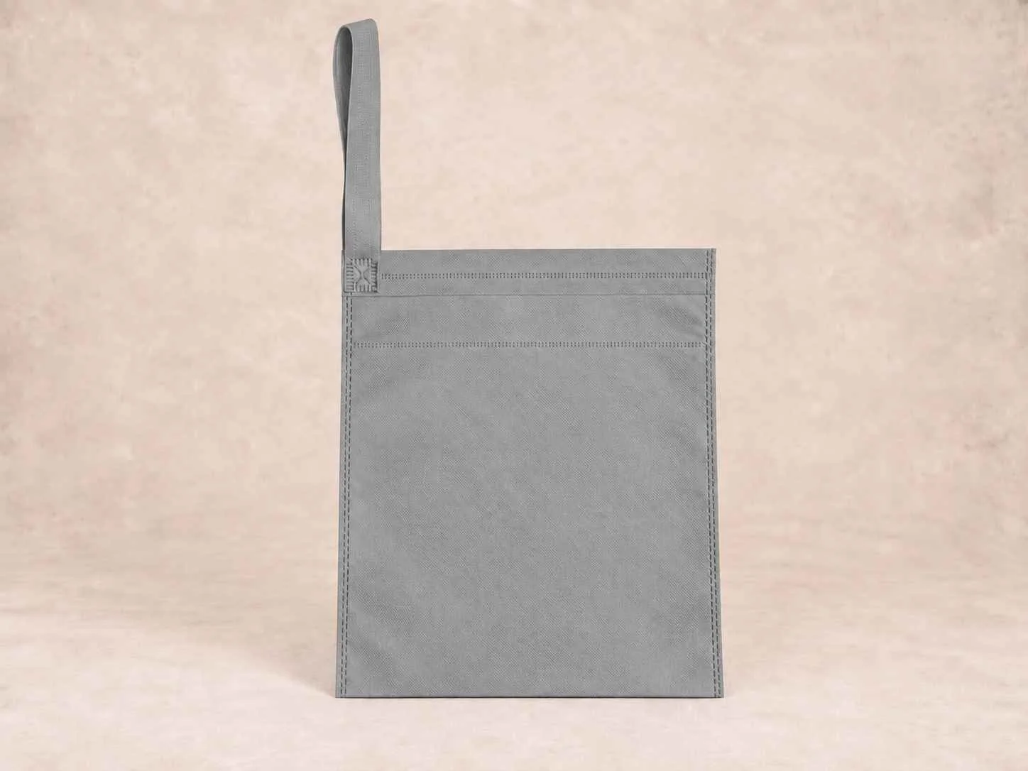  bolsa de cambrel reutilizable carro color gris de pie vertical sobre una superficie neutra contra un fondo neutro.