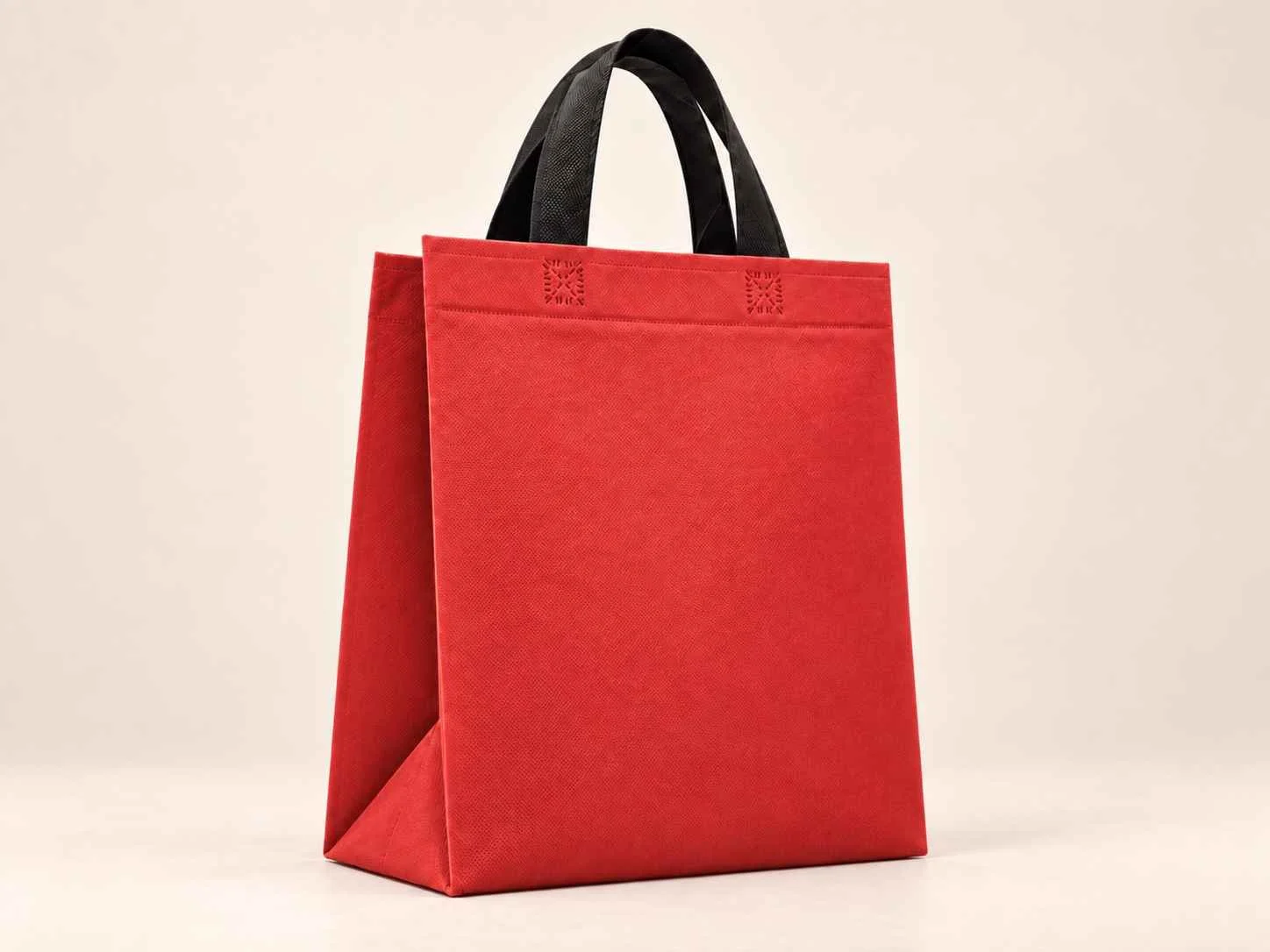 Bolsa 3 fuelles de cambrel reutilizable color rojo con manijas negras sobre un fondo neutro.