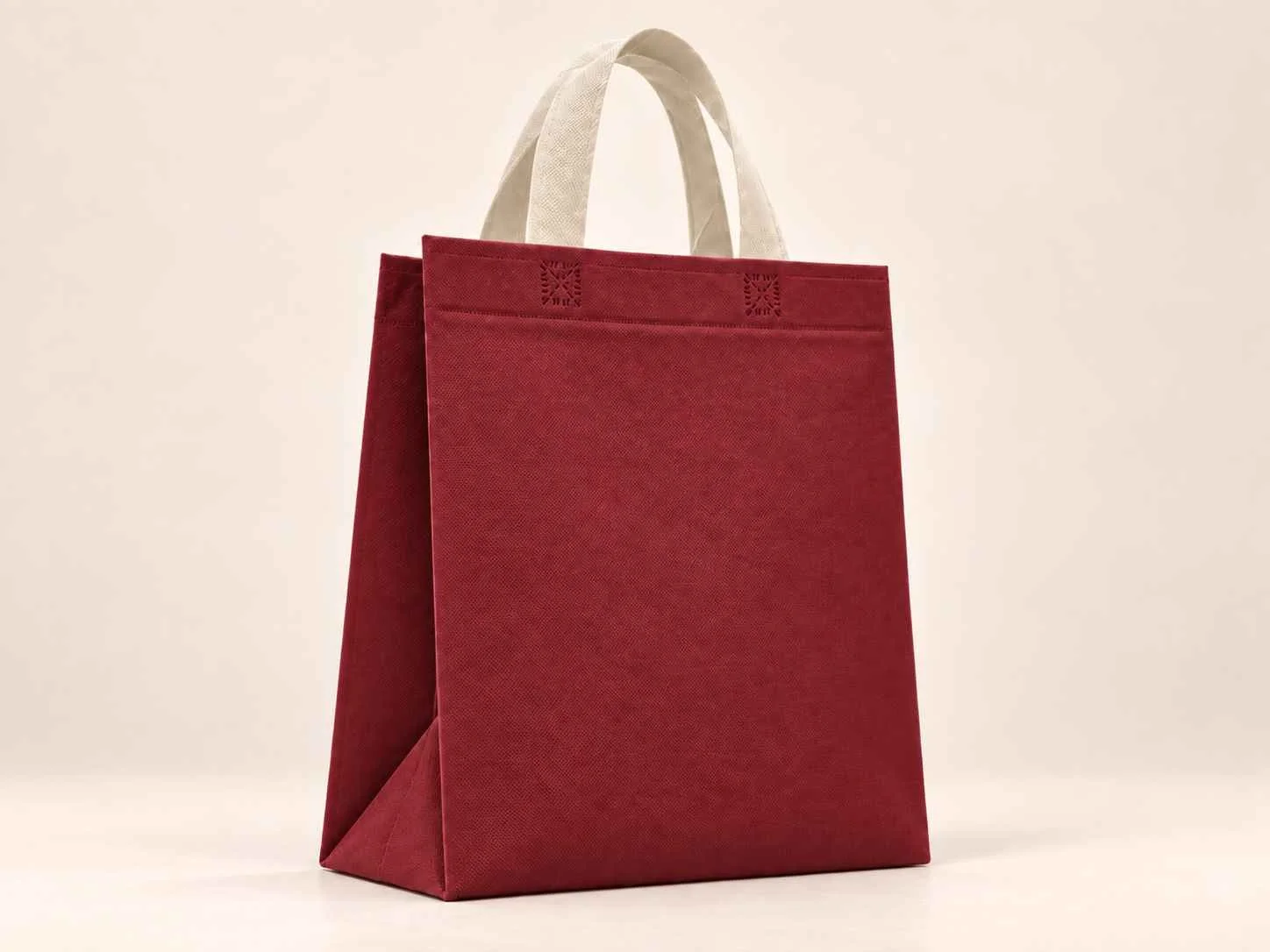 Bolsa 3 fuelles de cambrel reutilizable color vinotinto con manijas beige sobre un fondo neutro. 
