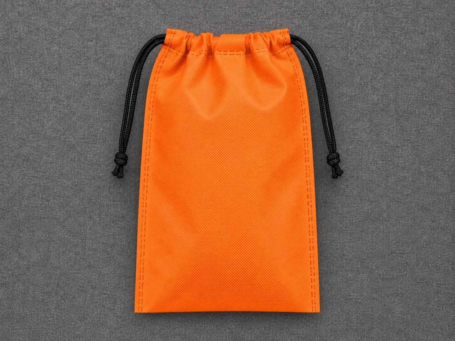 Orange drawstring bag with black cords on a gray background.