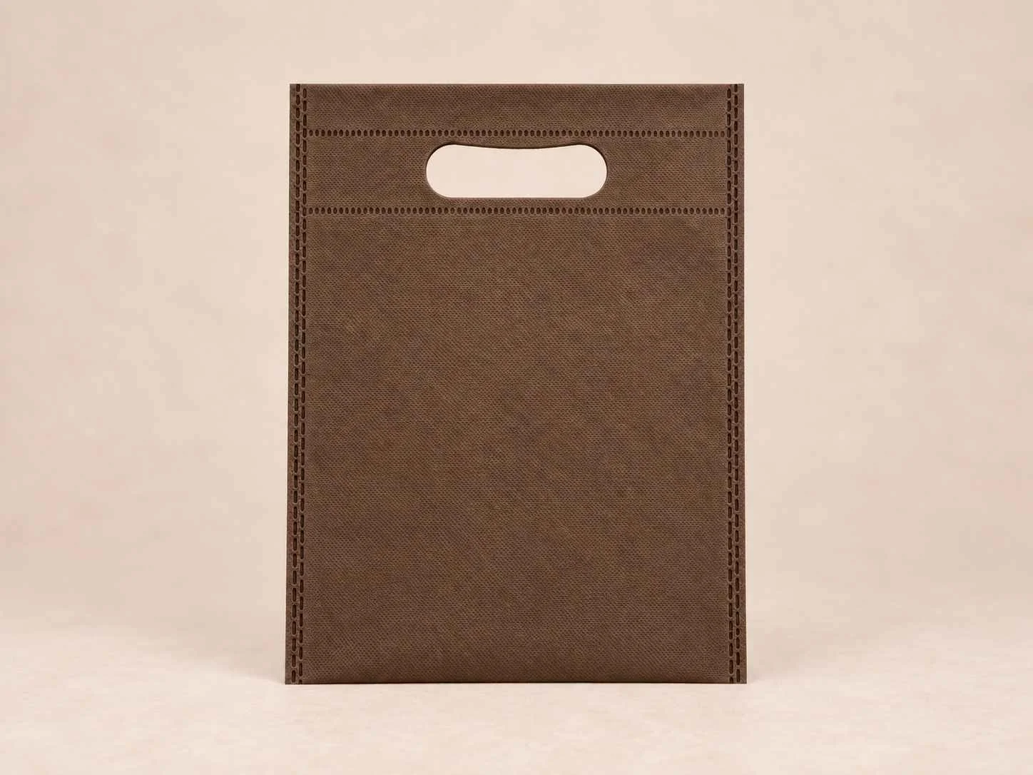 Bolsa de cambrel reutilizable plana troquelada color café sobre un fondo neutro.