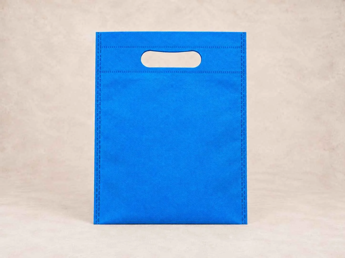 Bolsa de cambrel reutilizable plana troquelada color azul turquesa sobre un fondo neutro.